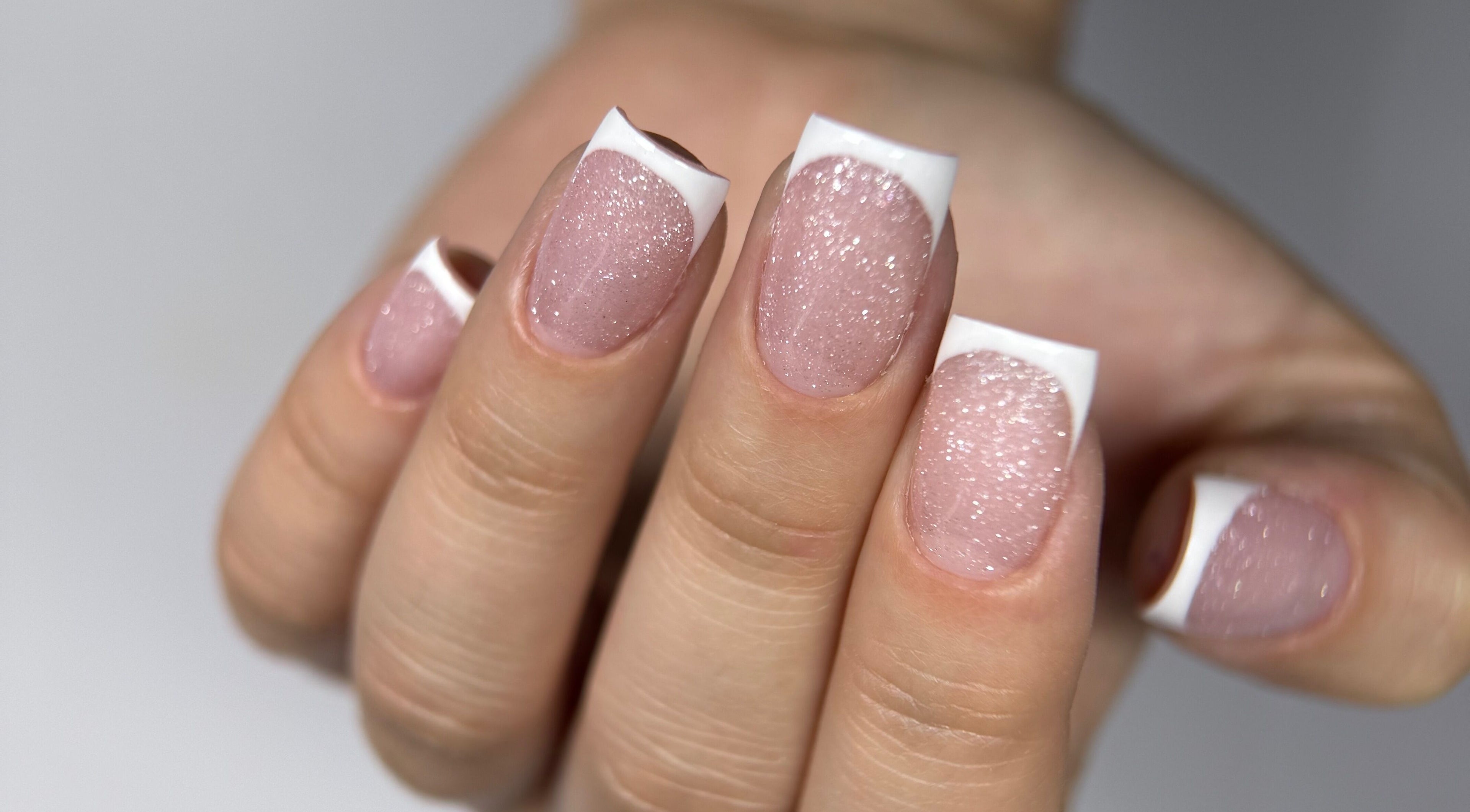 Glittery French manicure at Rita’s Nails, Portsmouth, England, GB, showcasing elegance and style.