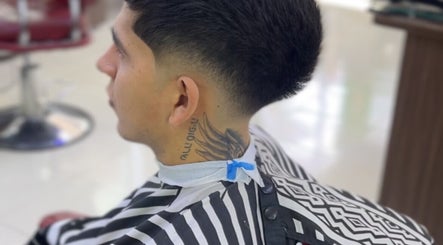 Corte de cabello moderno en Barberia Soccer Barber Shop, Cali, Valle Del Cauca, CO. Estilo impecable con tatuaje visible.