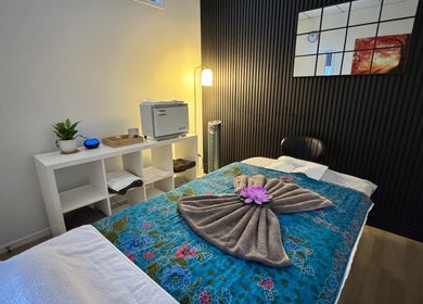 Cozy massage room at Massage Loft (Pukekohe), Pukekohe, Auckland, NZ, featuring soft lighting and floral decor.