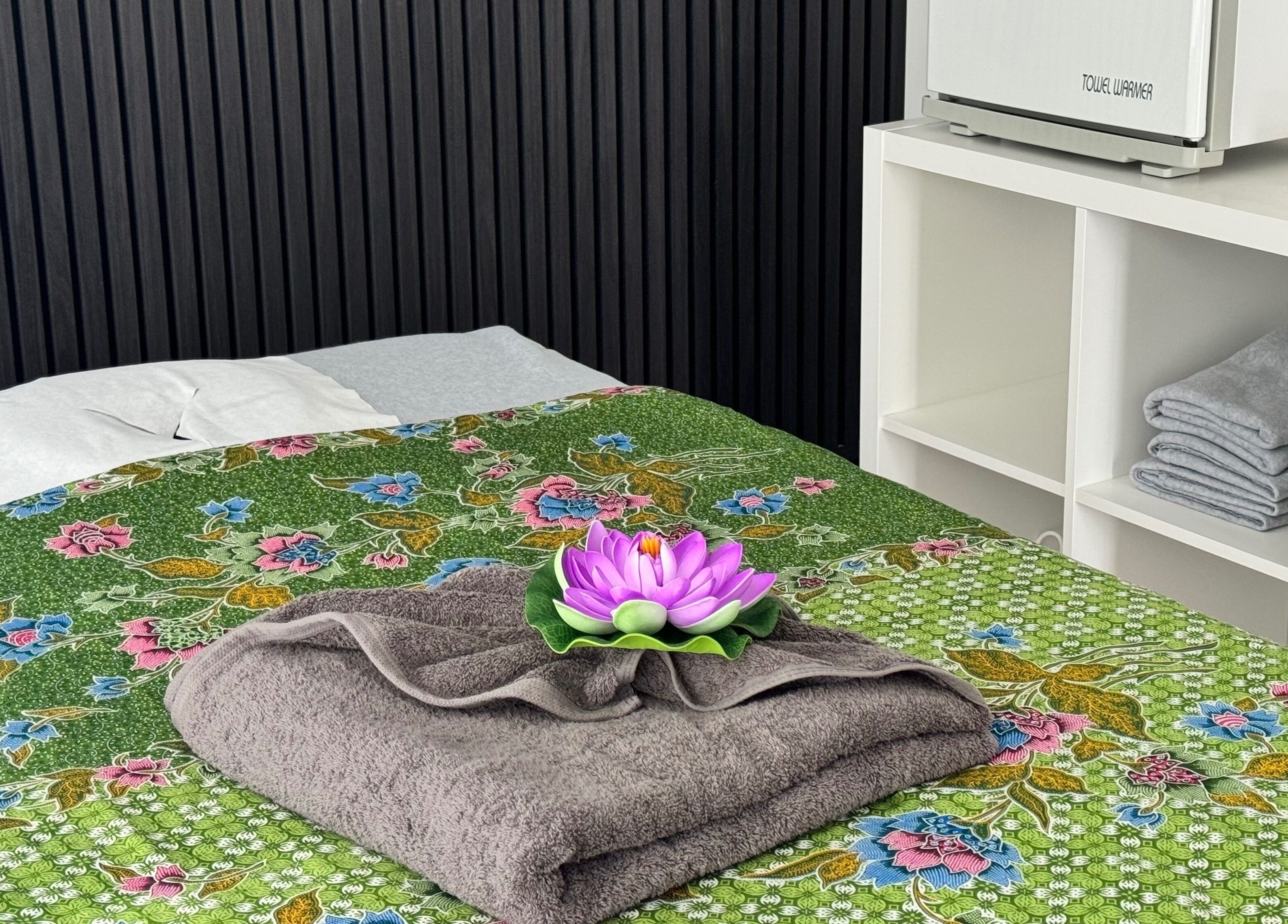 Massage table with floral sheet and towels at Massage Loft, Pukekohe, Auckland, NZ.