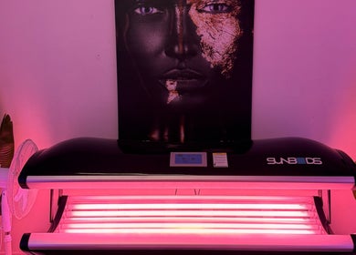 Sunbed at The Collarium Cult in Murarrie, Queensland, AU glows under vibrant pink lighting.