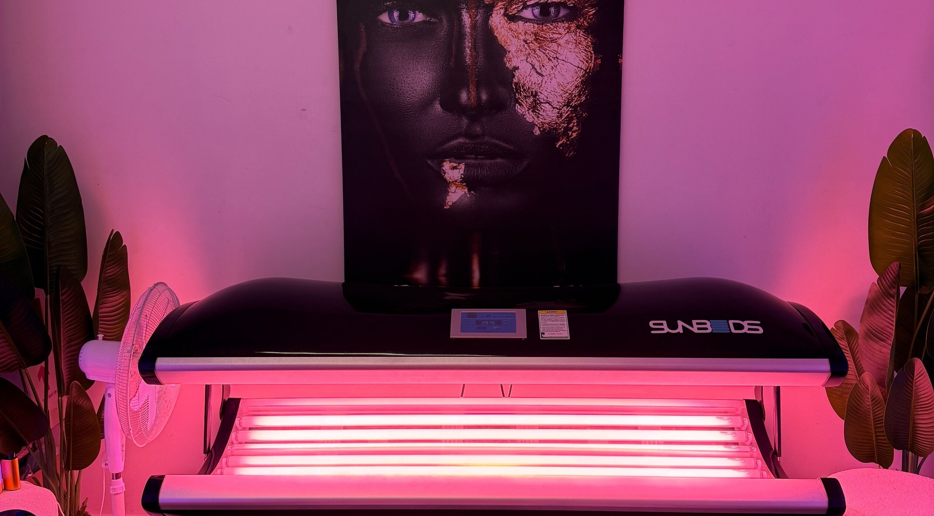 Sunbed at The Collarium Cult in Murarrie, Queensland, AU glows under vibrant pink lighting.