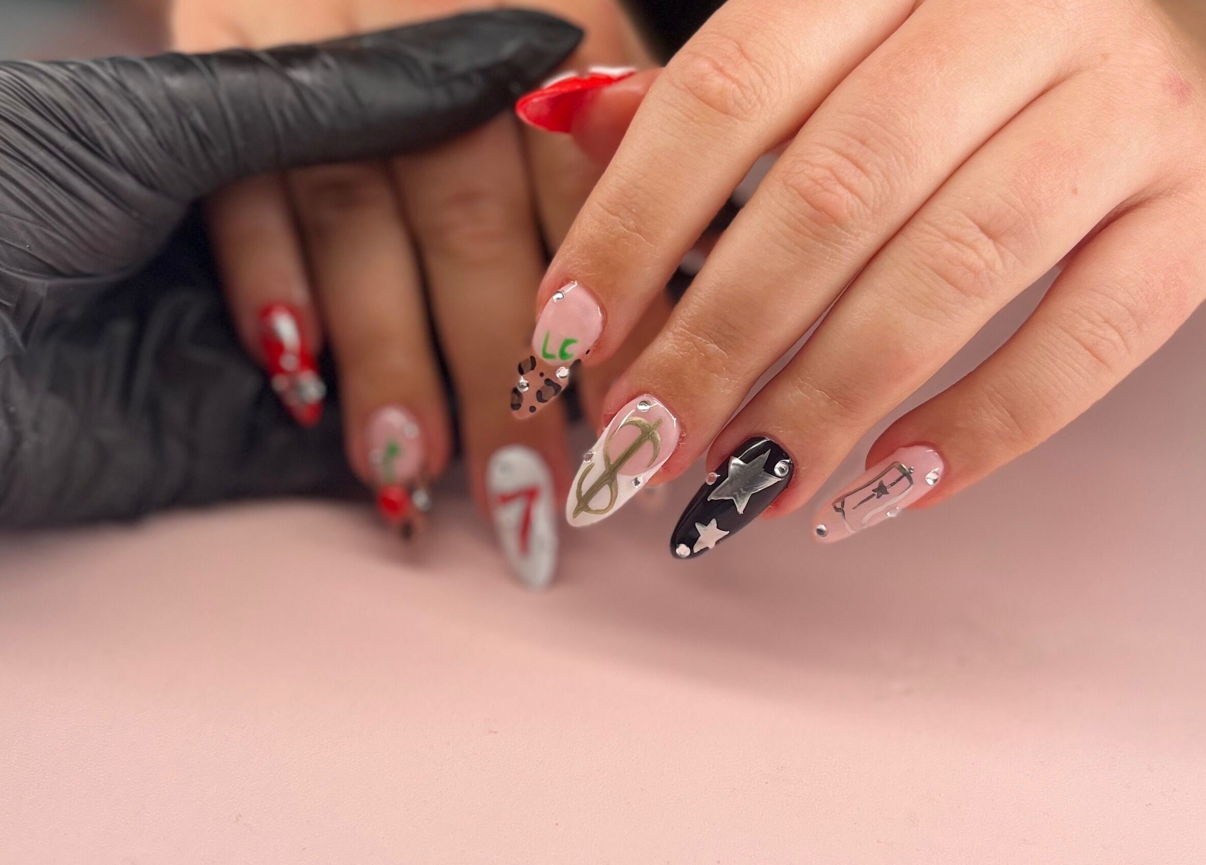 Intricate nail art at Mia's Manicures, Helston, England, GB showcasing detailed designs on a client's fingers.