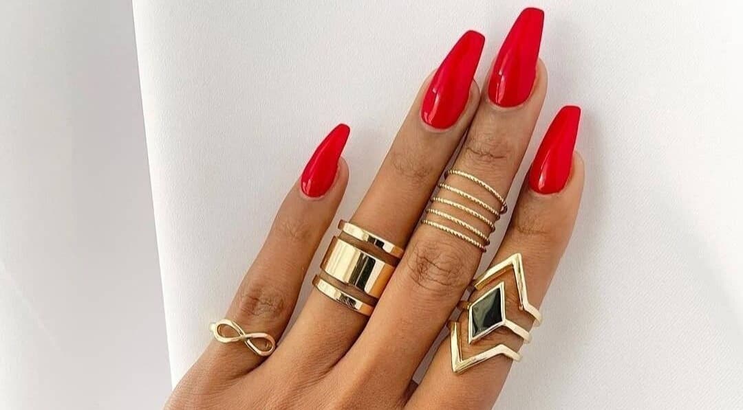 Stylish red manicured nails with gold rings at T-Royals Beauty, Cape Town, Western Cape, ZA.