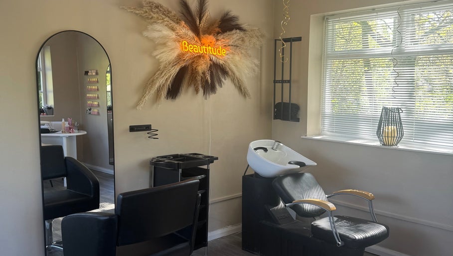 Stylish salon setup at Beautitude, Clitheroe, England featuring a modern chair and illuminated decor.
