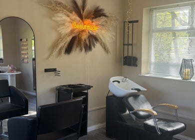 Stylish salon setup at Beautitude, Clitheroe, England featuring a modern chair and illuminated decor.