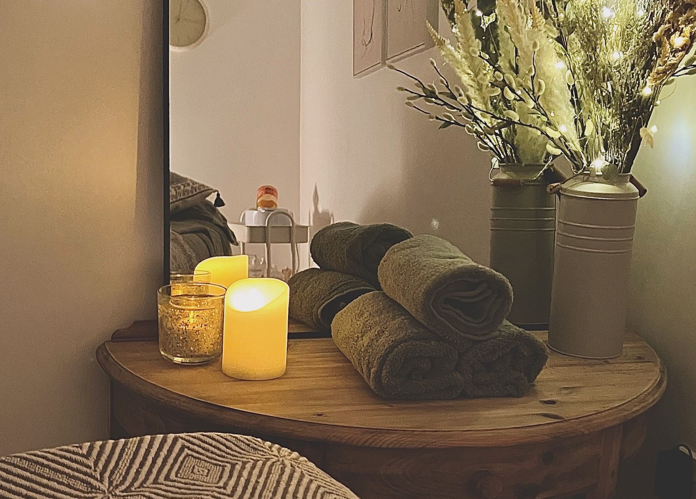 Cozy spa room with rolled towels, candles, and decor at Beauty Hub, Peterborough, England, GB.