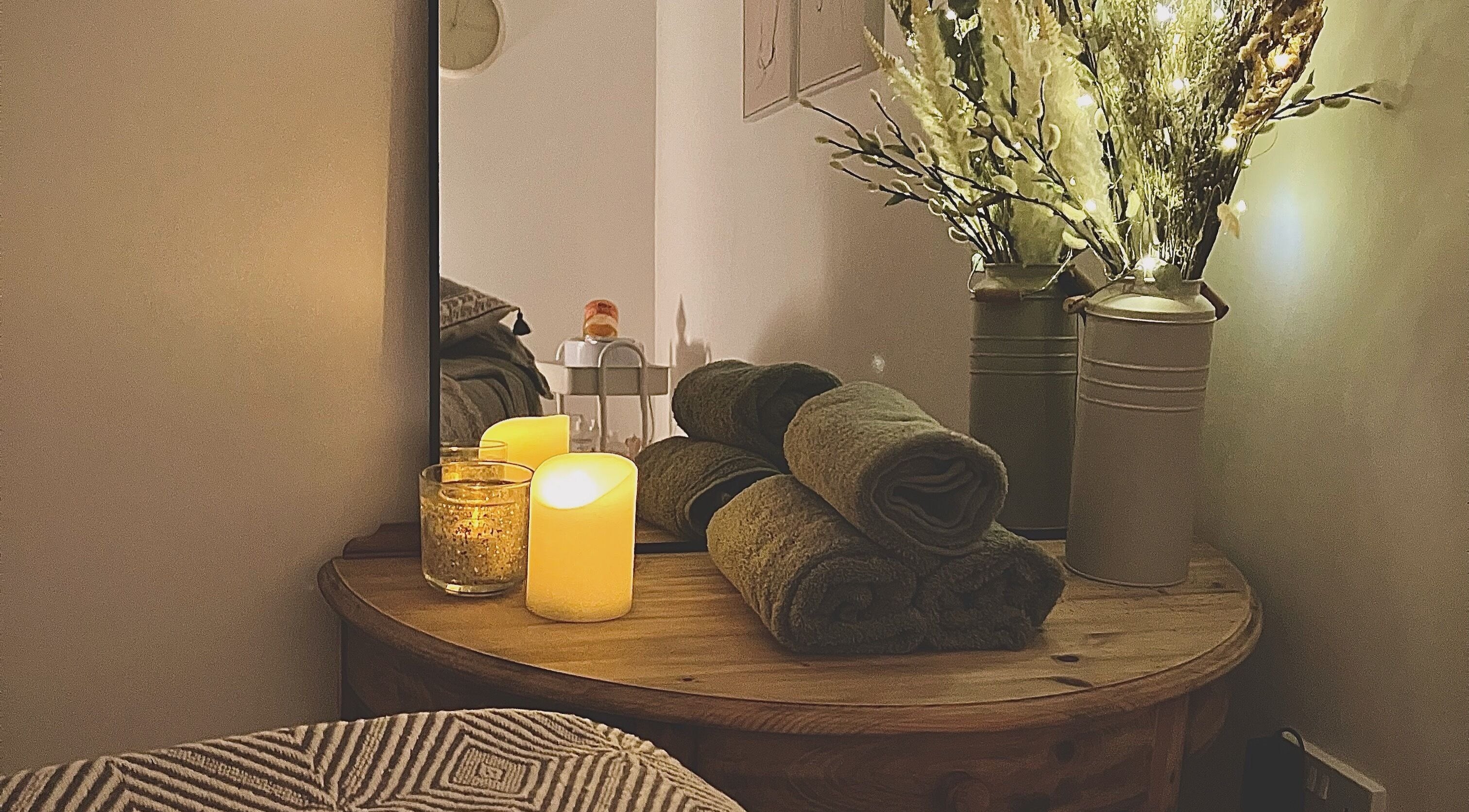 Cozy spa room with rolled towels, candles, and decor at Beauty Hub, Peterborough, England, GB.