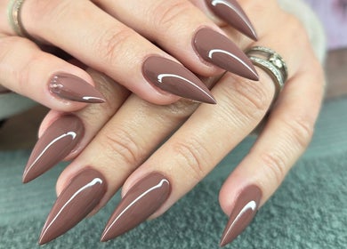 Glossy brown stiletto nails manicured at Daniella Nail Studio, Randburg, Gauteng, ZA.