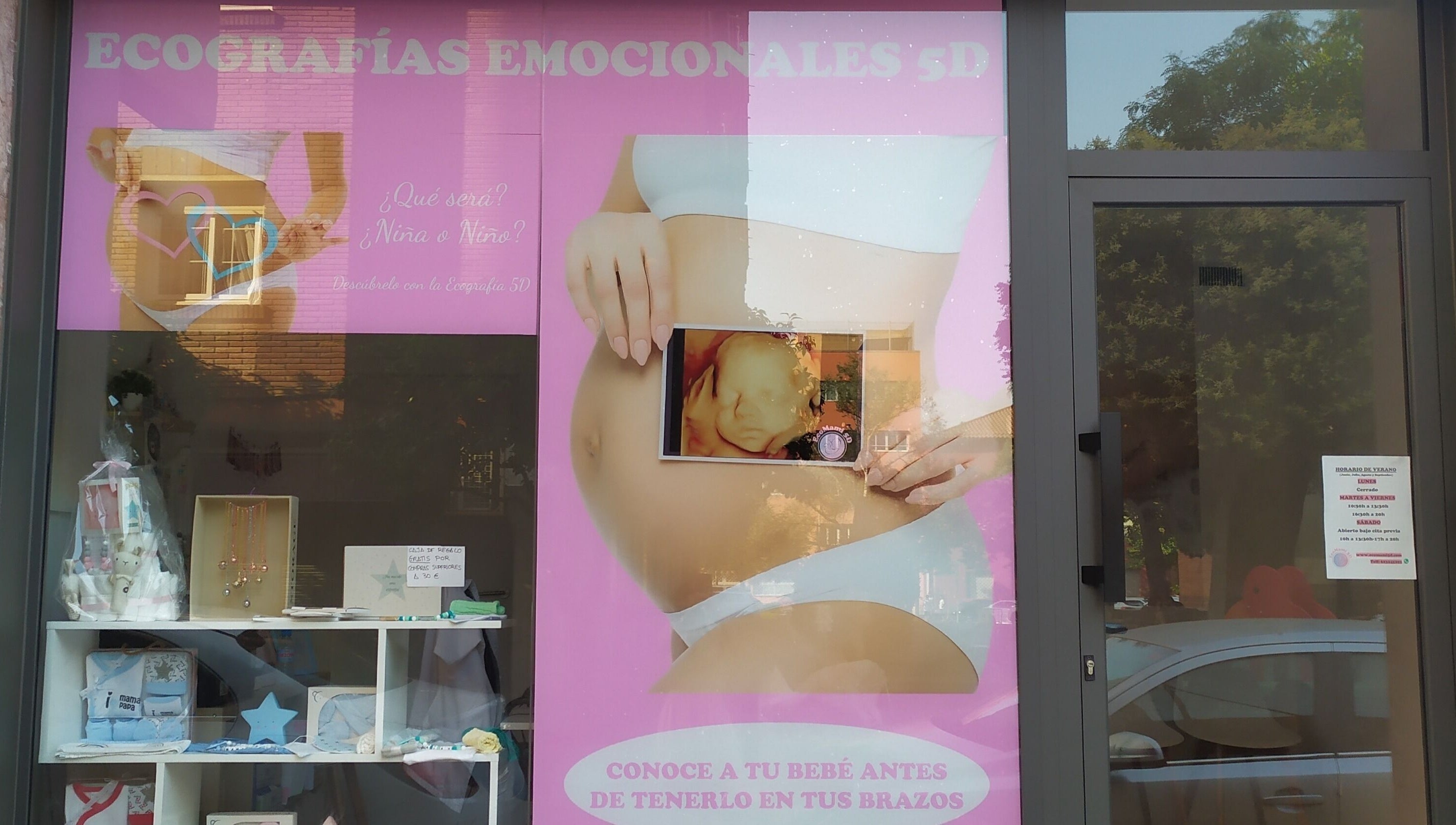 Fachada de EcoMami 5D en Gavà, Catalunya, ES, destacando ecografías emocionales en un vibrante cartel rosa.
