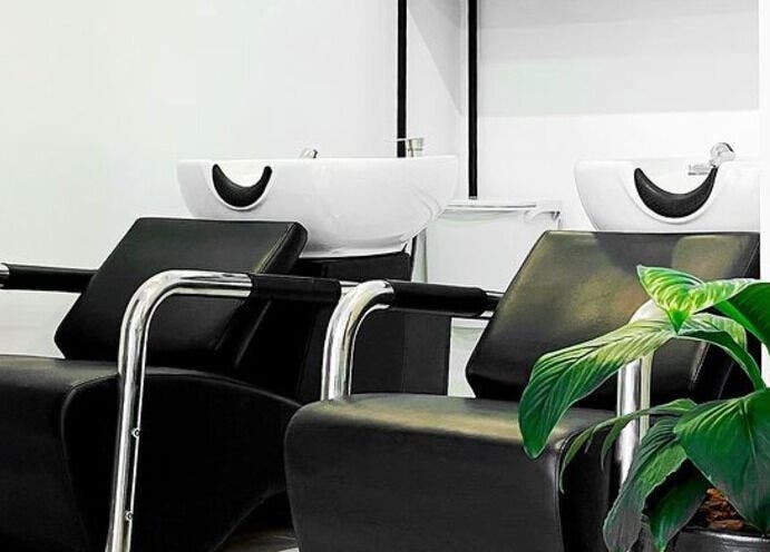 Zona de lavado moderna en Luca Salone, Asunción, Asunción, PY con sillas negras y una planta decorativa.