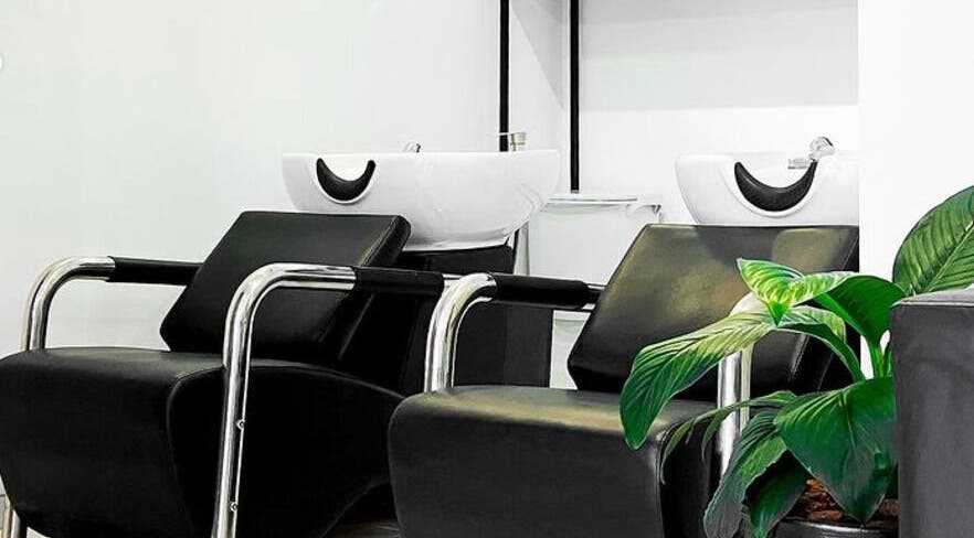 Zona de lavado moderna en Luca Salone, Asunción, Asunción, PY con sillas negras y una planta decorativa.