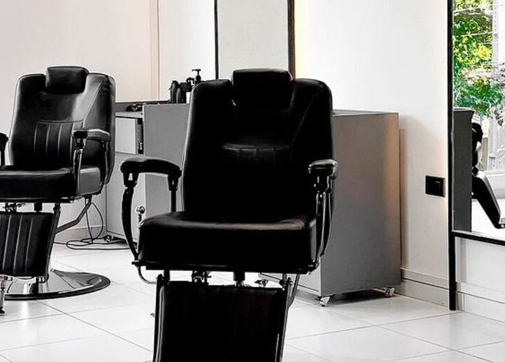 Interior del Luca Salone en Asunción, PY con sillas de peluquería negras y decoración minimalista.