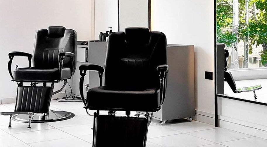 Interior del Luca Salone en Asunción, PY con sillas de peluquería negras y decoración minimalista.