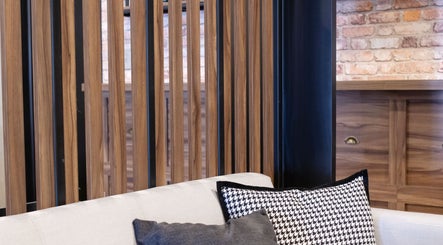 Interior moderno de The Beard Co. en Santiago De Querétaro, Querétaro, MX, con paredes de madera y cojines elegantes.