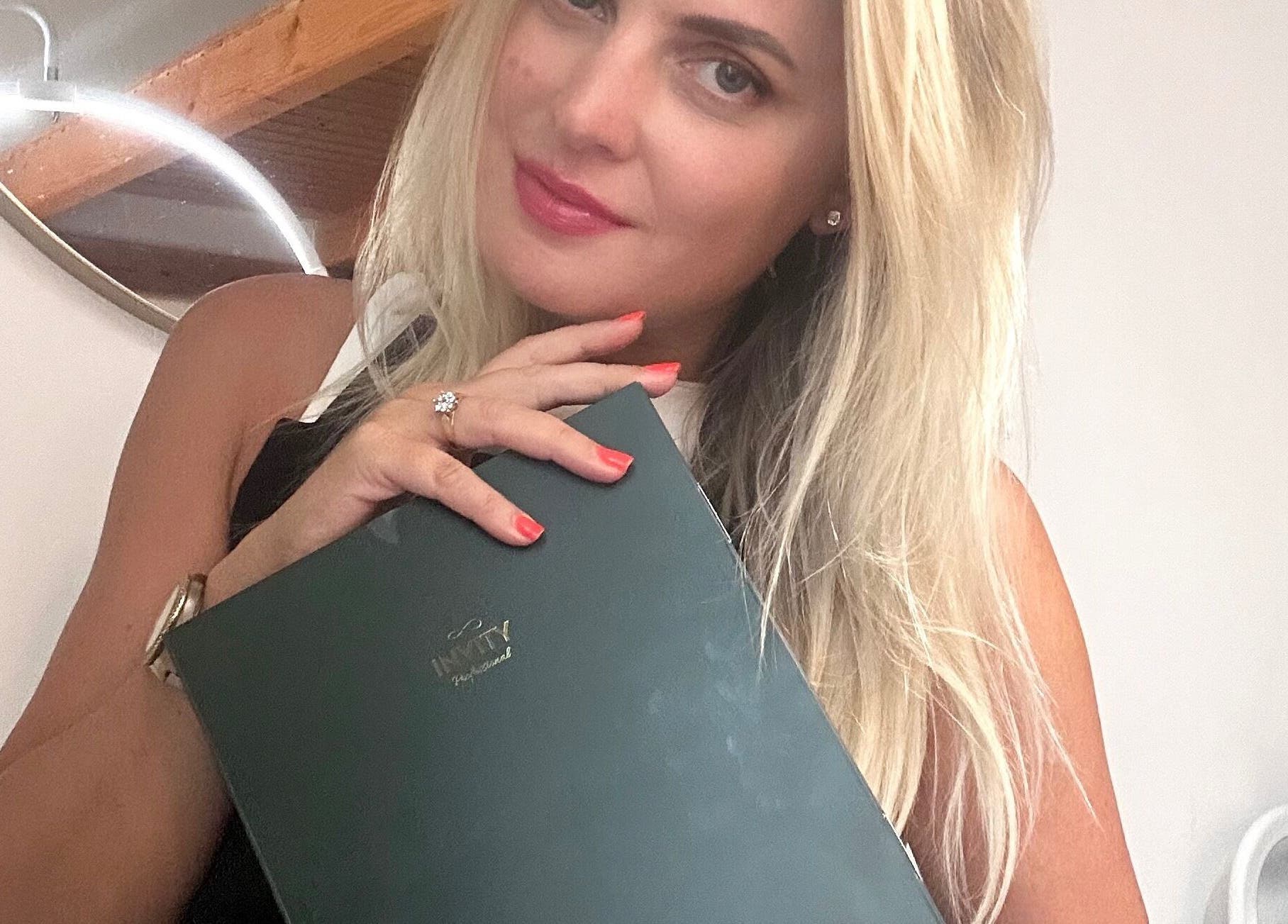 Žena v Kosmetický salon Beauty Hair Health Skinlab by K, Hlavní Město Praha, s kosmetickou knihou.