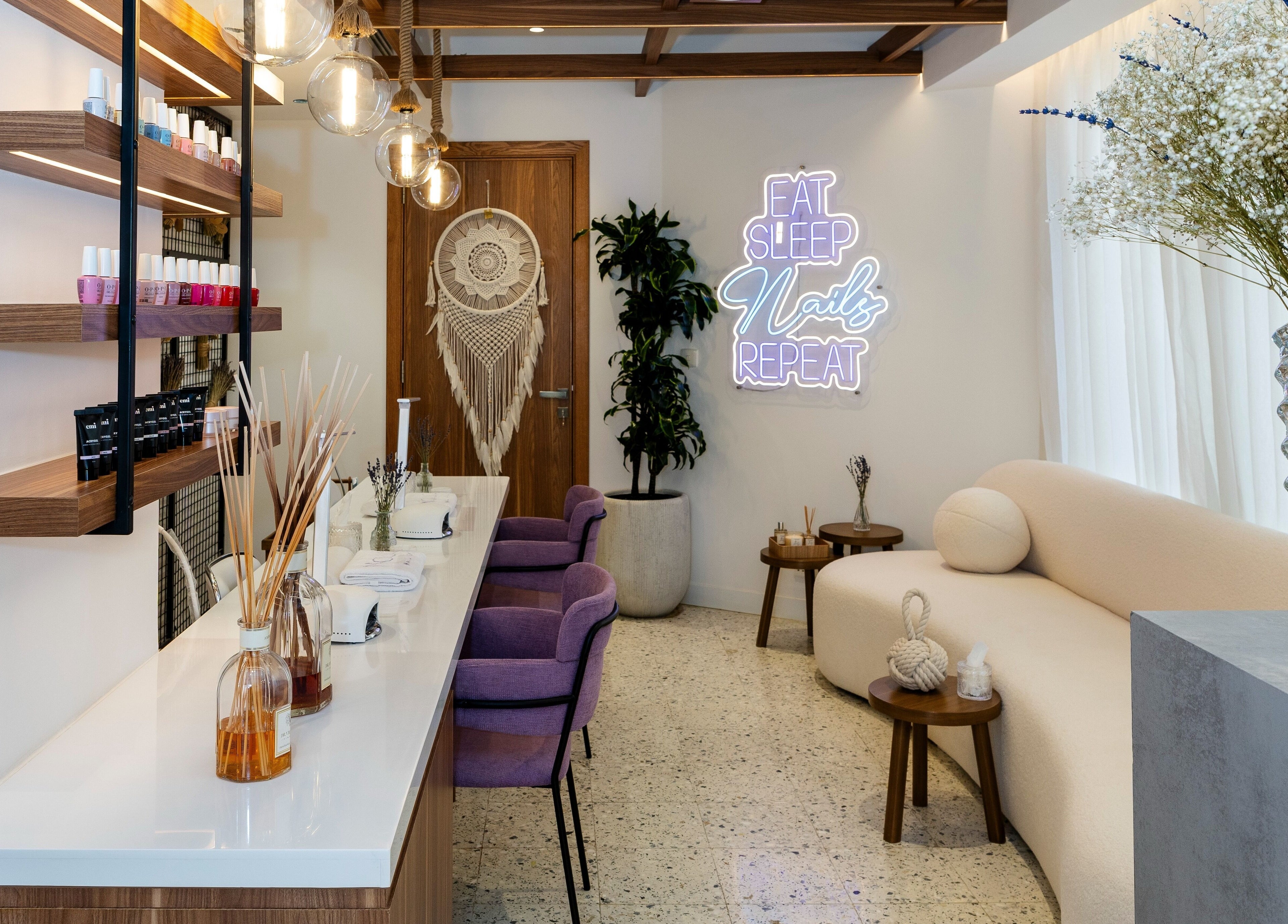 Chic Noluci Spa nail salon interior with purple chairs and neon sign, الرياض, SA.