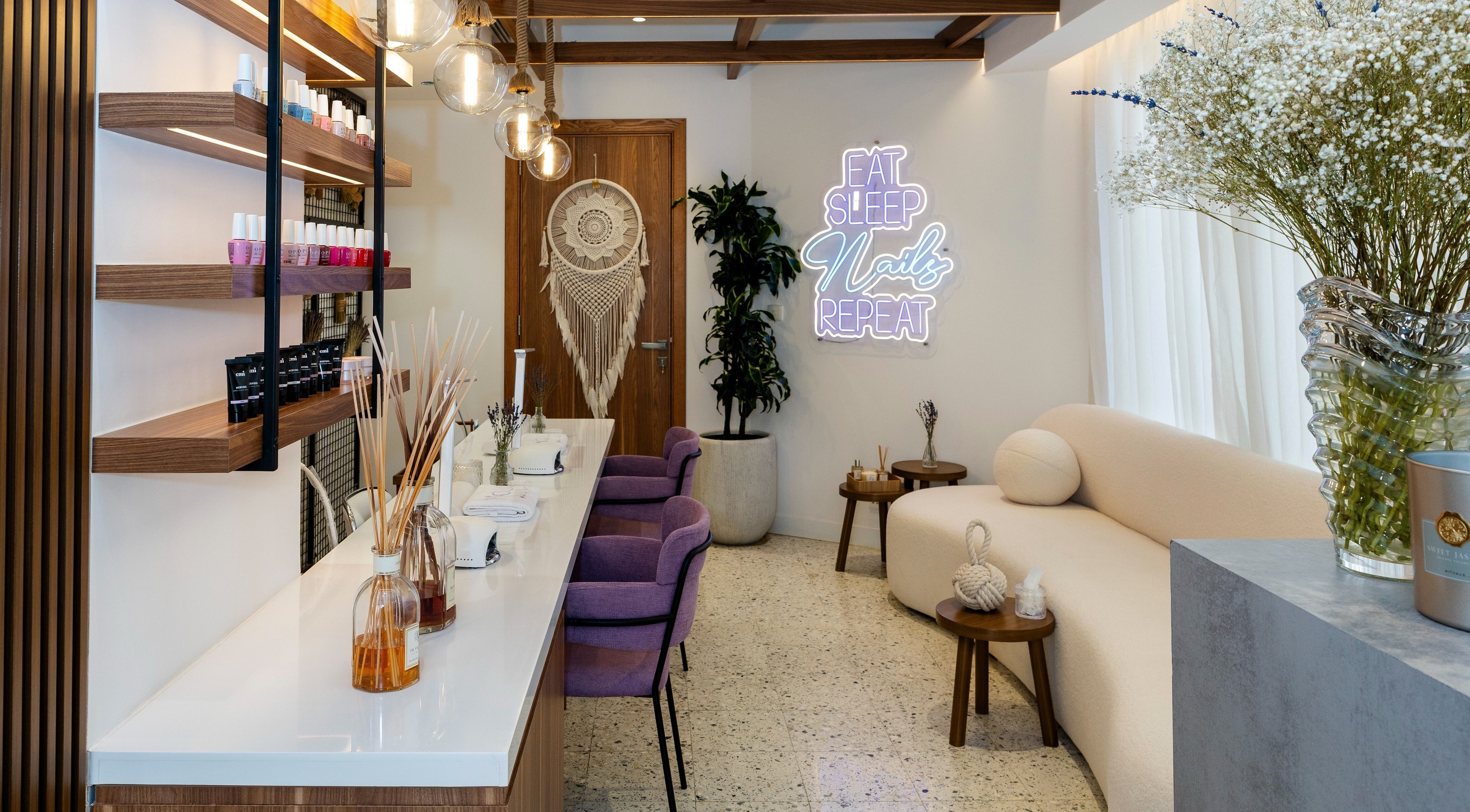 Chic Noluci Spa nail salon interior with purple chairs and neon sign, الرياض, SA.