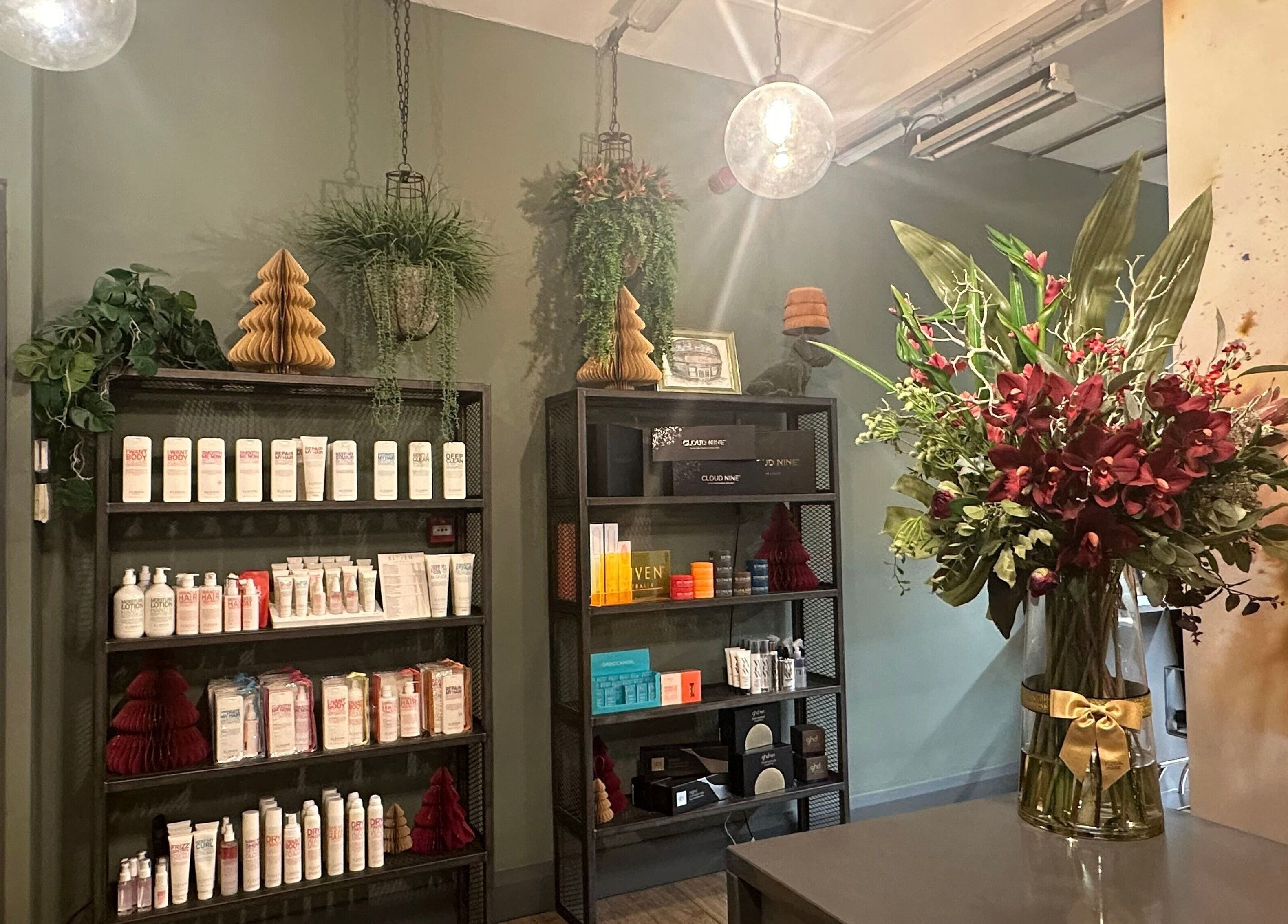 Inside So & So Hairdressing in Whitley Bay, England, showcasing products, greenery, and a floral arrangement.