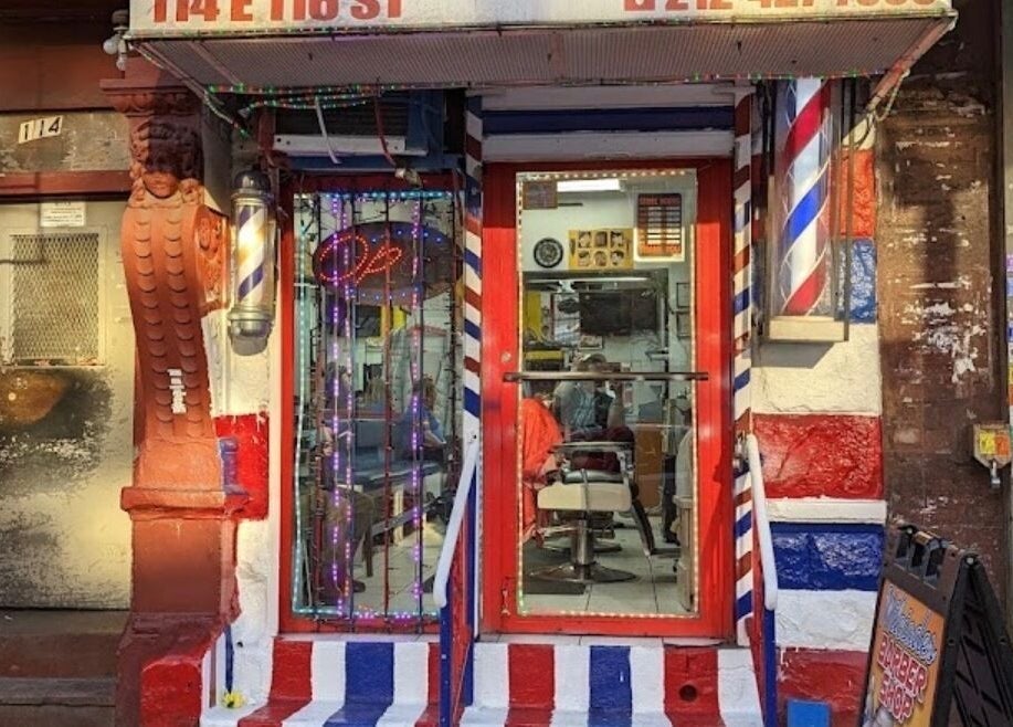 Front entrance of BarberingRicky, a vibrant barbershop in New York, New York, US with classic barber pole.
