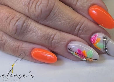 Stylish nail art with orange and floral designs at Melonie's Nail Salon, Hastings, England, GB.