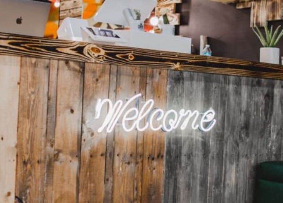 Welcome sign at Choppers Barbershop reception in Miami, Florida, US with rustic wooden decor.