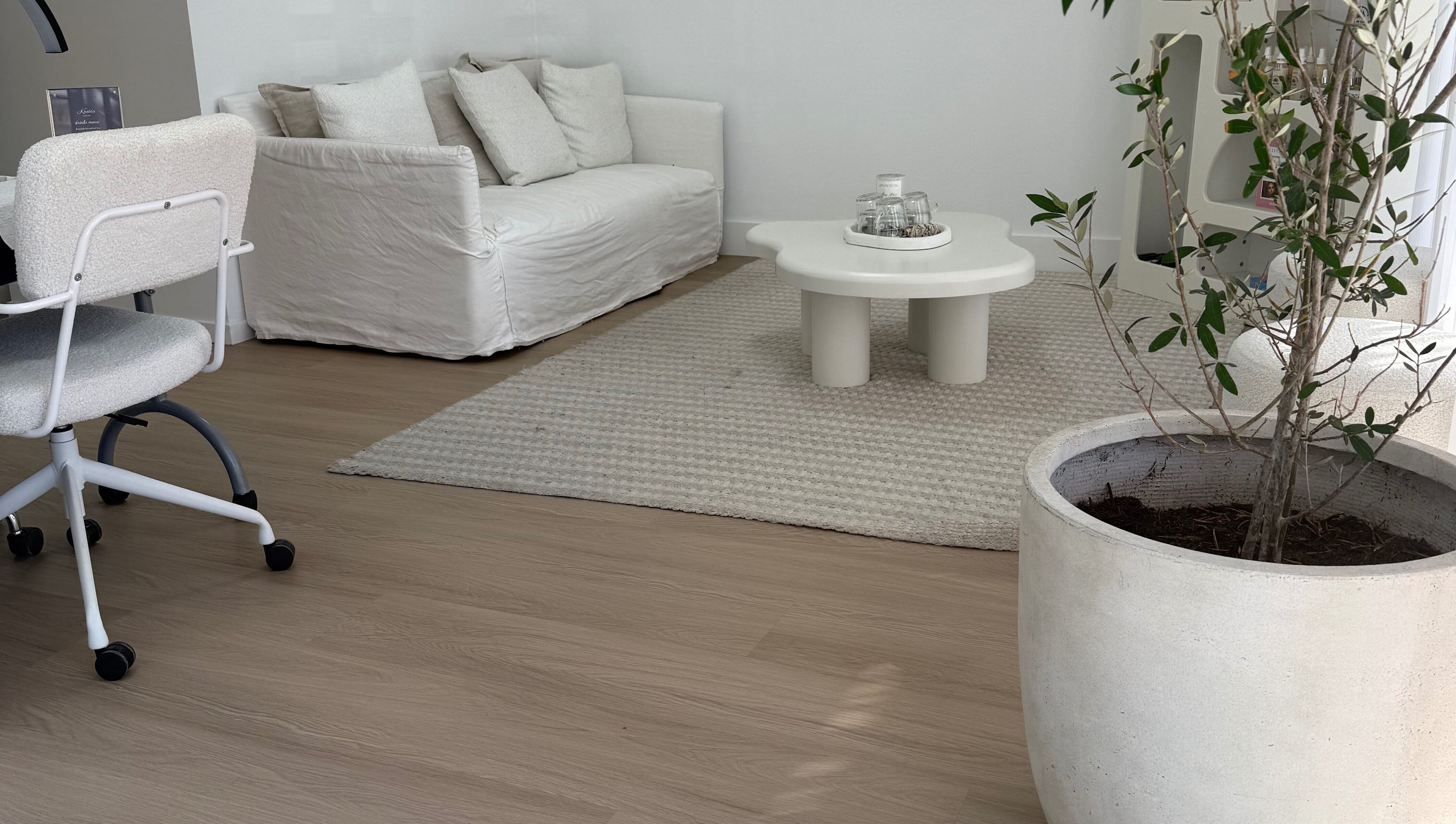 Elegant lounge area with white sofa at The House of Lashes Beauty Bar, Robina, Queensland, AU.