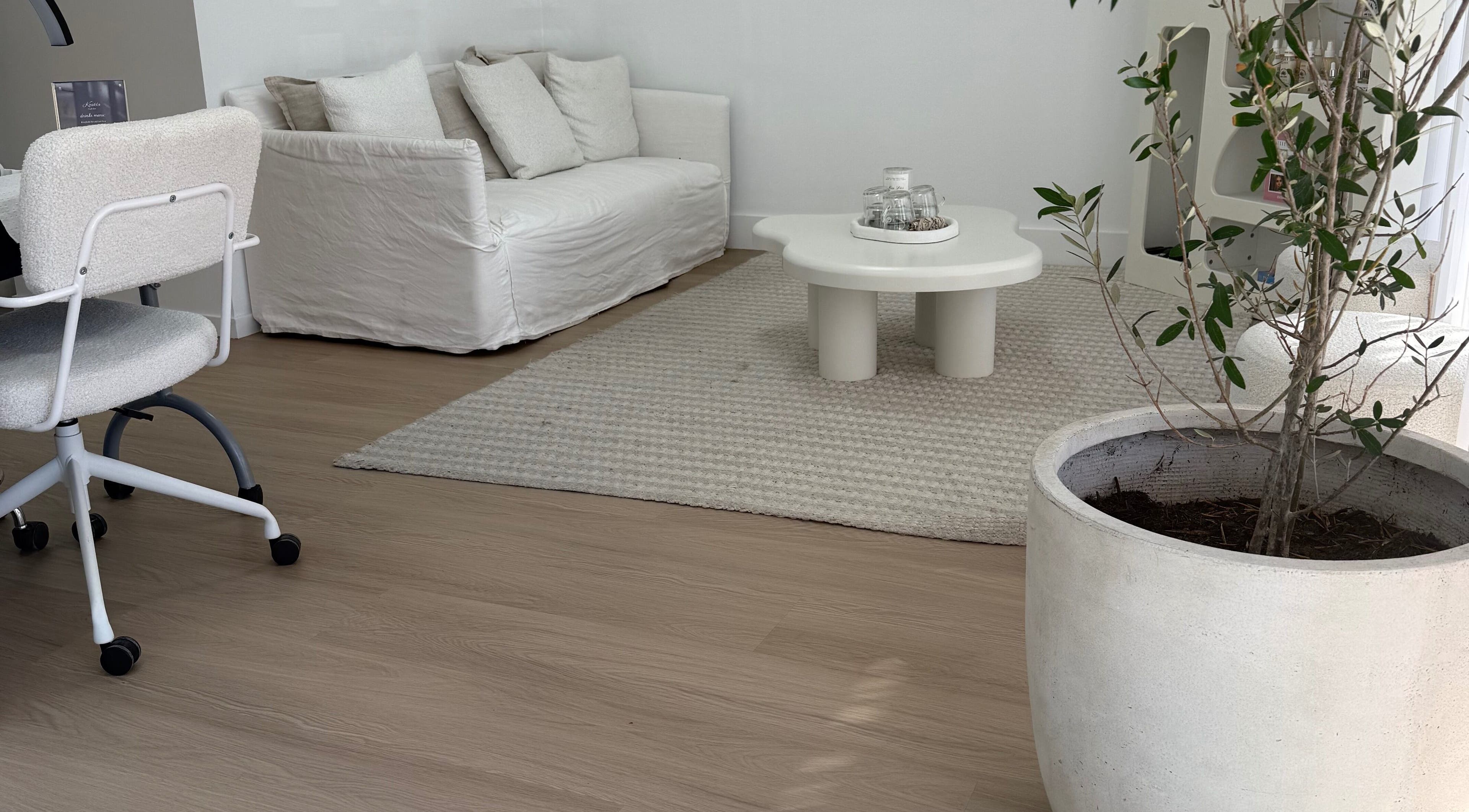 Elegant lounge area with white sofa at The House of Lashes Beauty Bar, Robina, Queensland, AU.