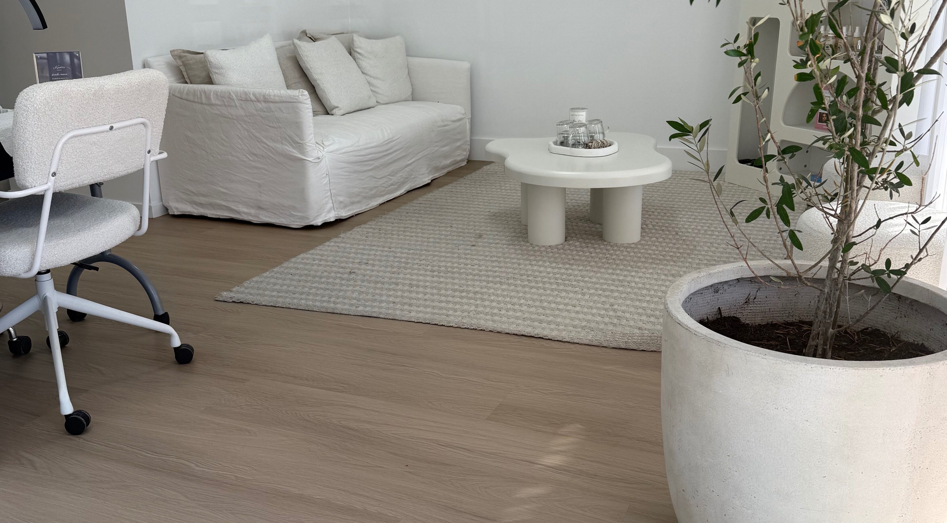 Elegant lounge area with white sofa at The House of Lashes Beauty Bar, Robina, Queensland, AU.