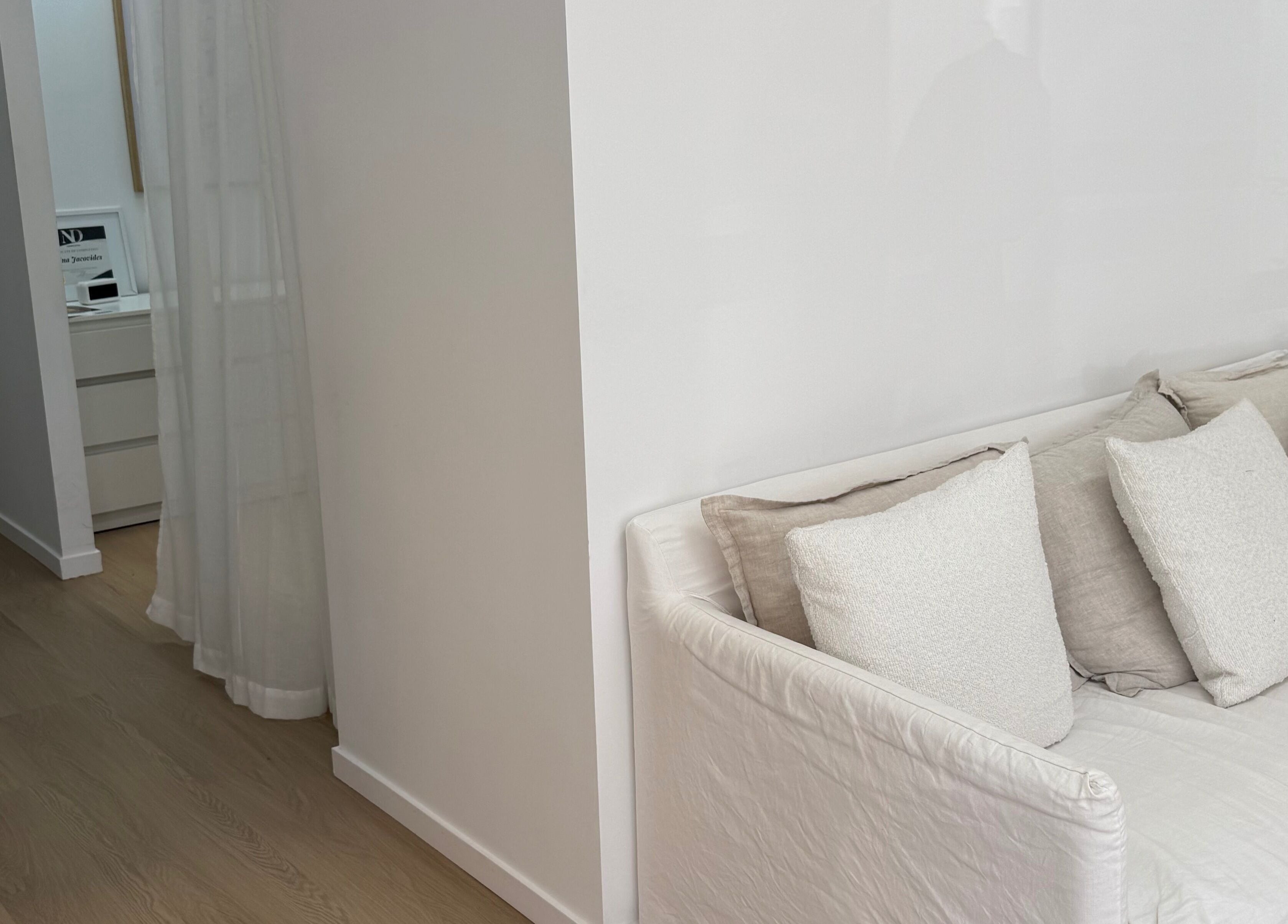 Chic lounge corner at The House of Lashes Beauty Bar in Robina, Queensland, AU with soft white cushions.