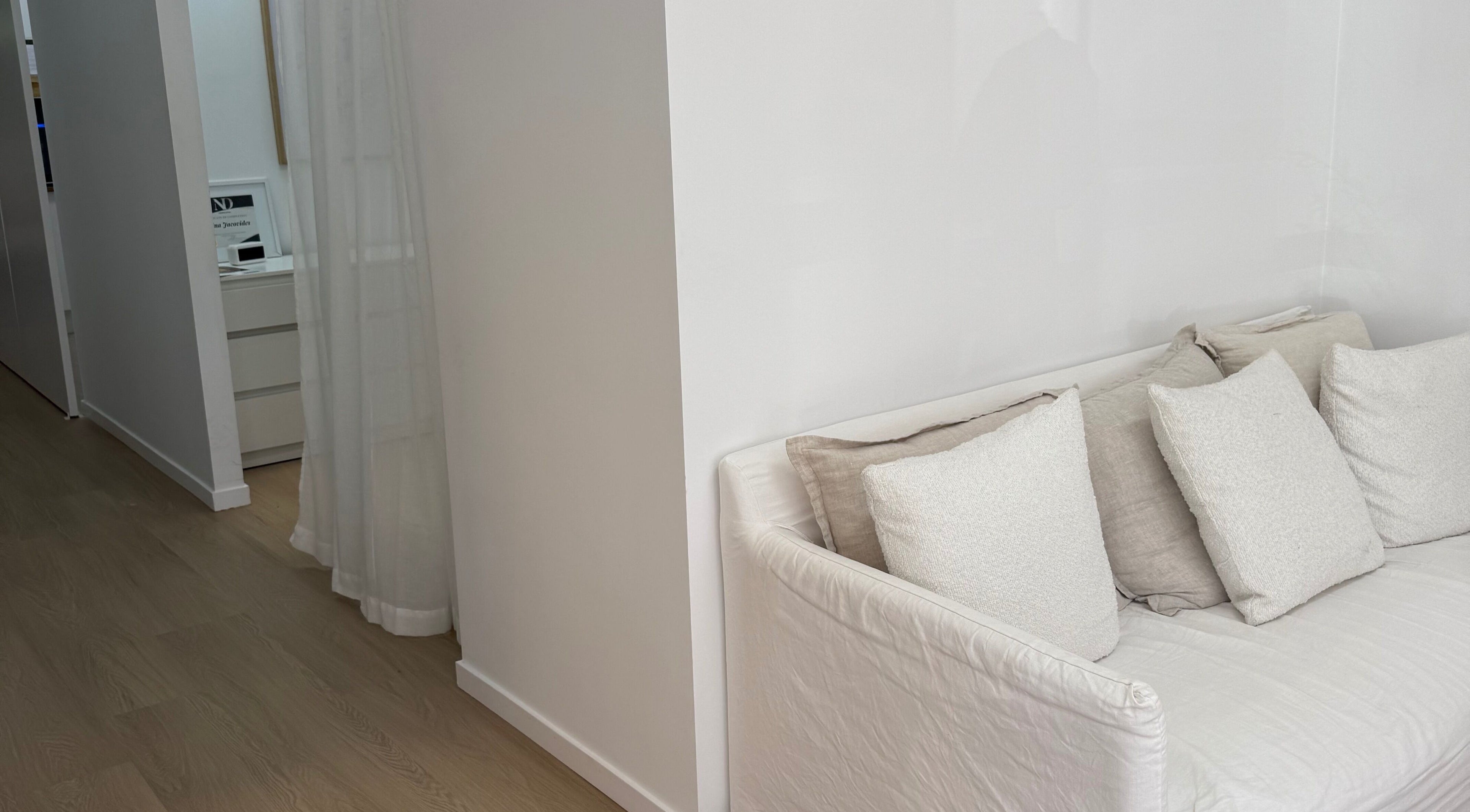 Chic lounge corner at The House of Lashes Beauty Bar in Robina, Queensland, AU with soft white cushions.