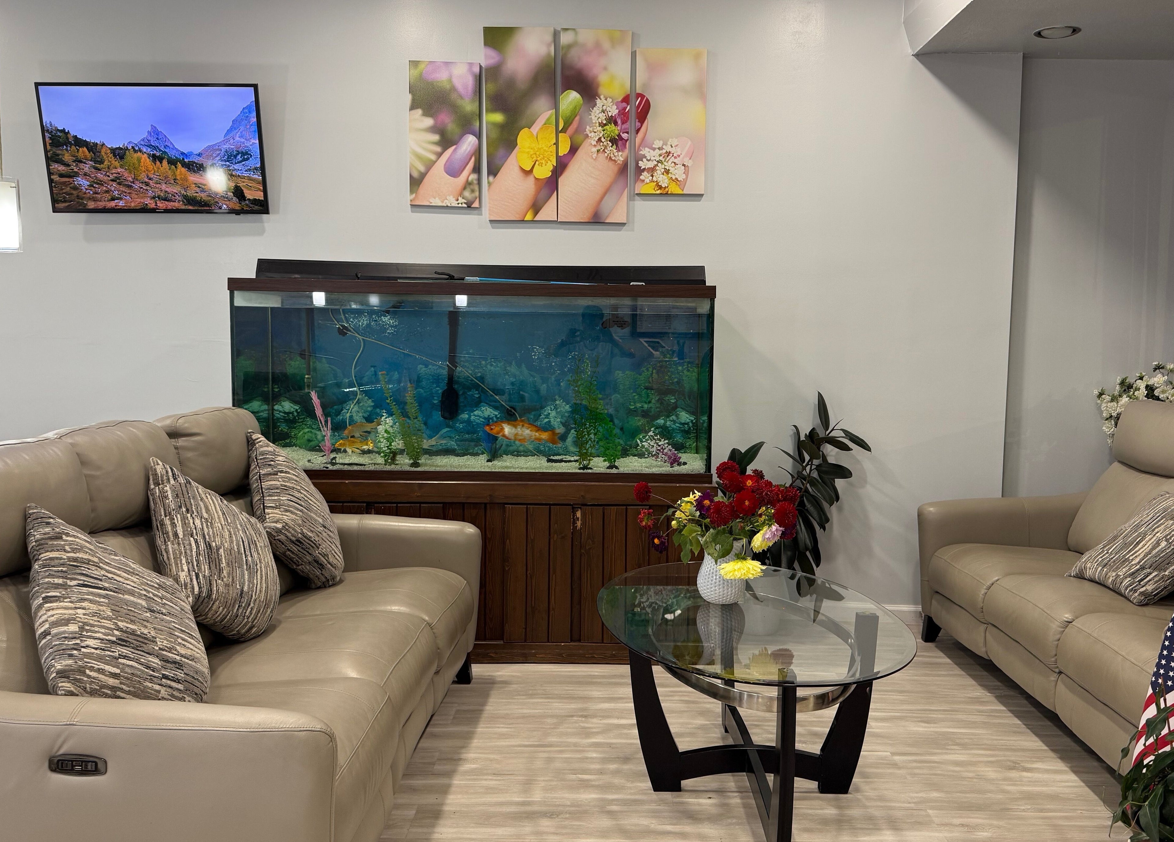 Cozy lounge at A&T NAIL SALON, Somerville, New Jersey, US with sofas, aquarium, and vibrant decor.