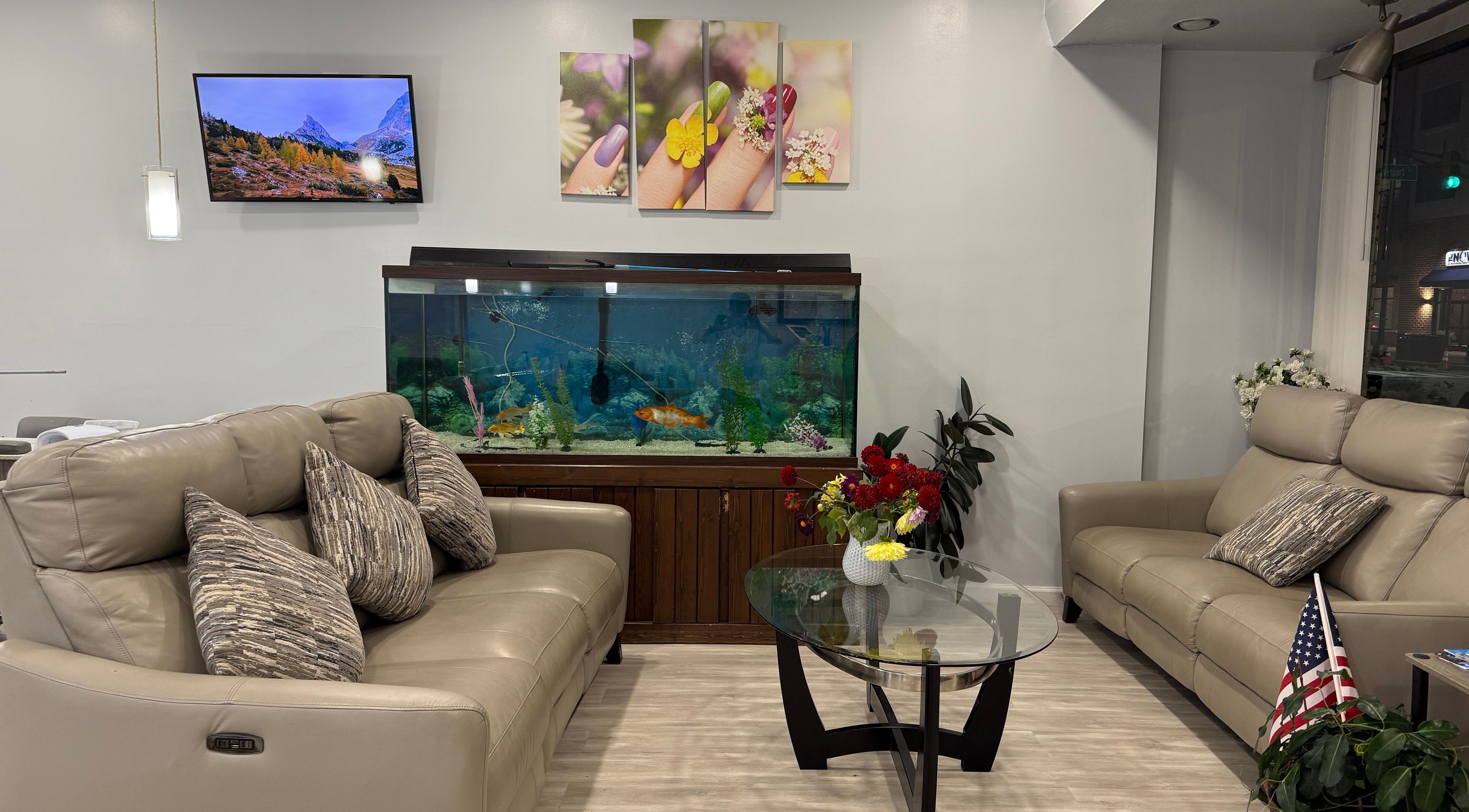 Cozy lounge at A&T NAIL SALON, Somerville, New Jersey, US with sofas, aquarium, and vibrant decor.