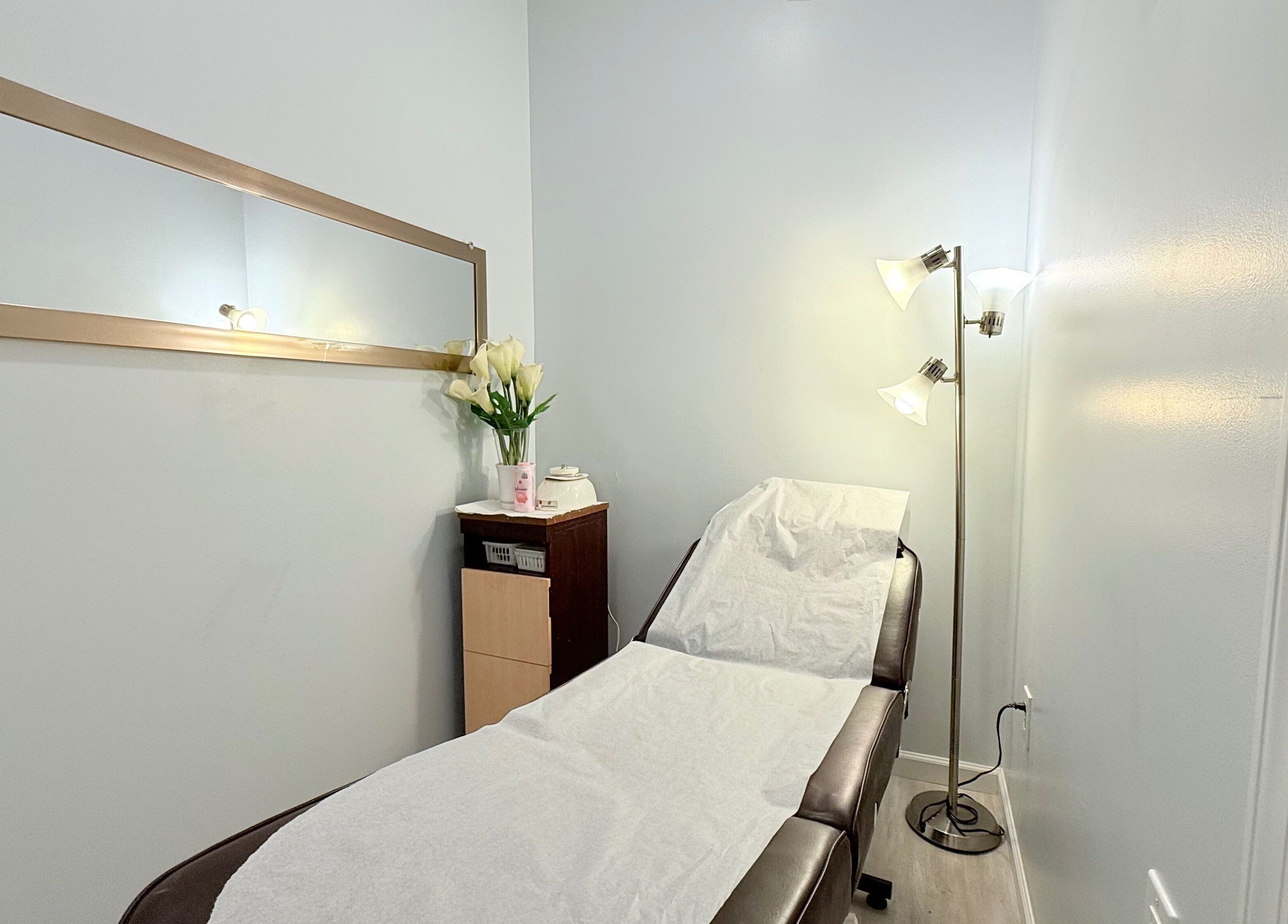 Cozy treatment room at A&T NAIL SALON, Somerville, New Jersey with spa bed and elegant decor.