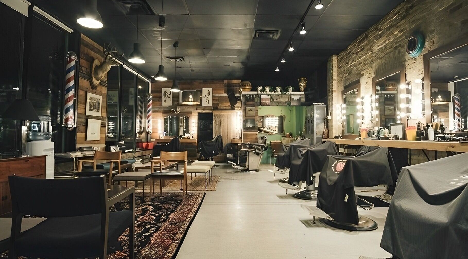 Cozy interior of The Loving Barbers Company in Winnipeg, Manitoba, CA featuring stylish rustic decor and barber chairs.