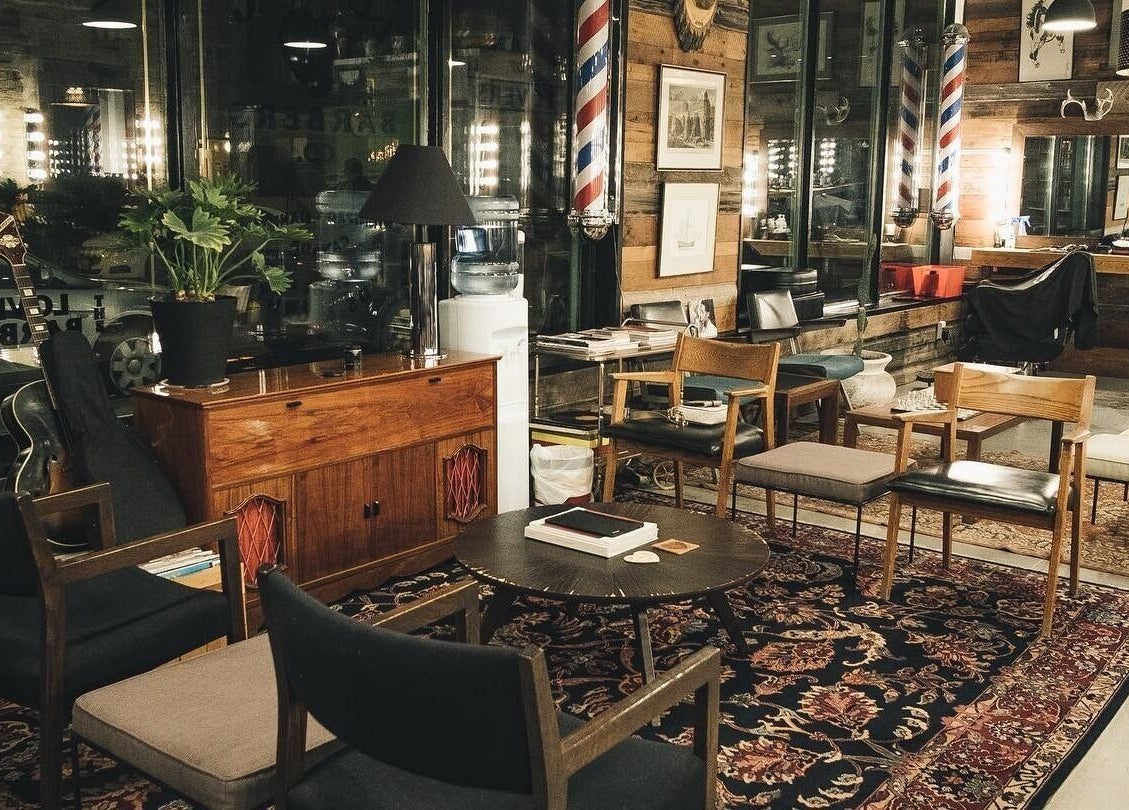 Cozy vintage lounge at The Loving Barbers Company, Winnipeg, Manitoba, CA, with armchairs and a patterned rug.