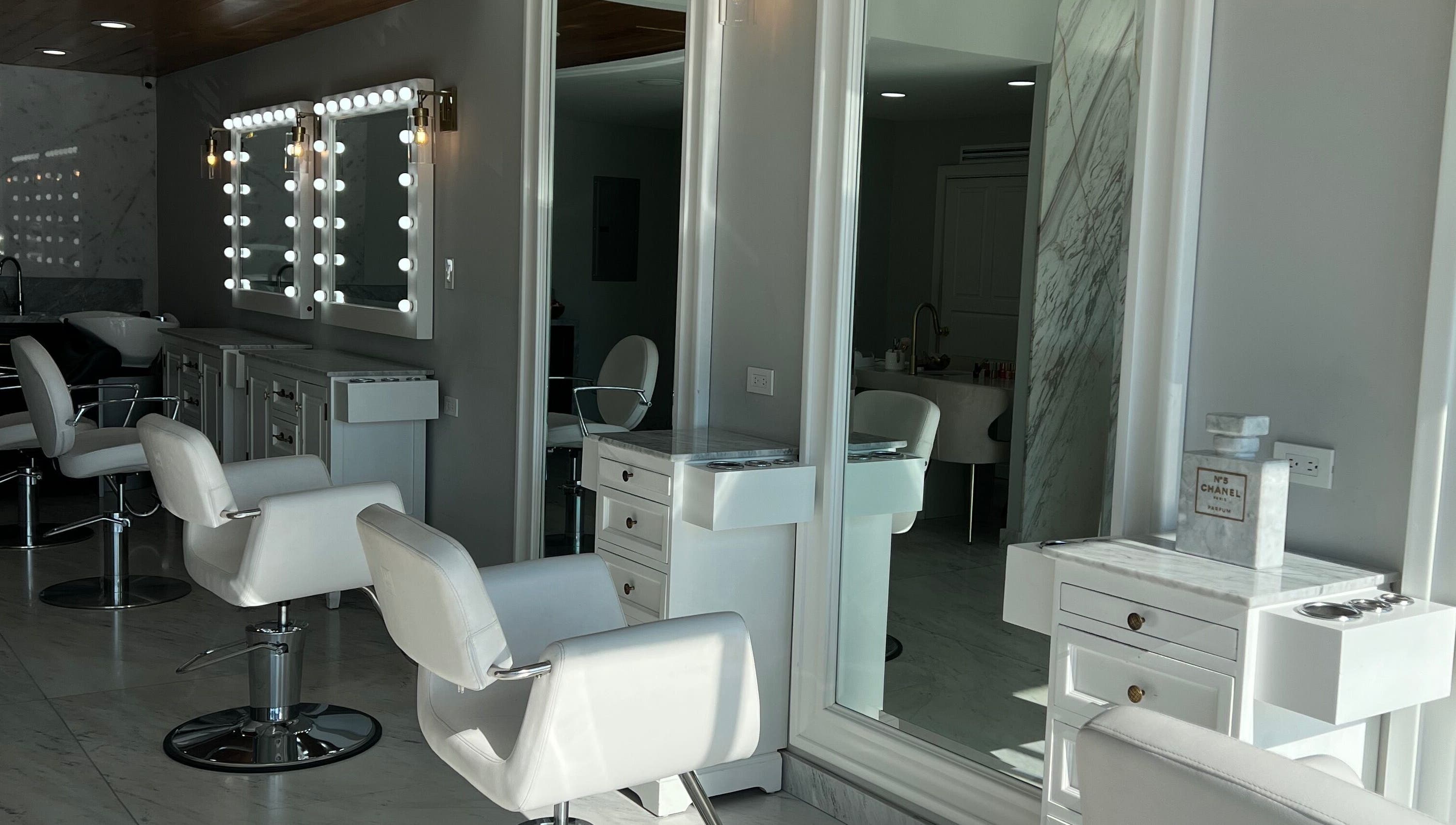 Interiores elegantes de VICA STUDIO, Chihuahua, Chihuahua, MX con sillas blancas y espejos iluminados.