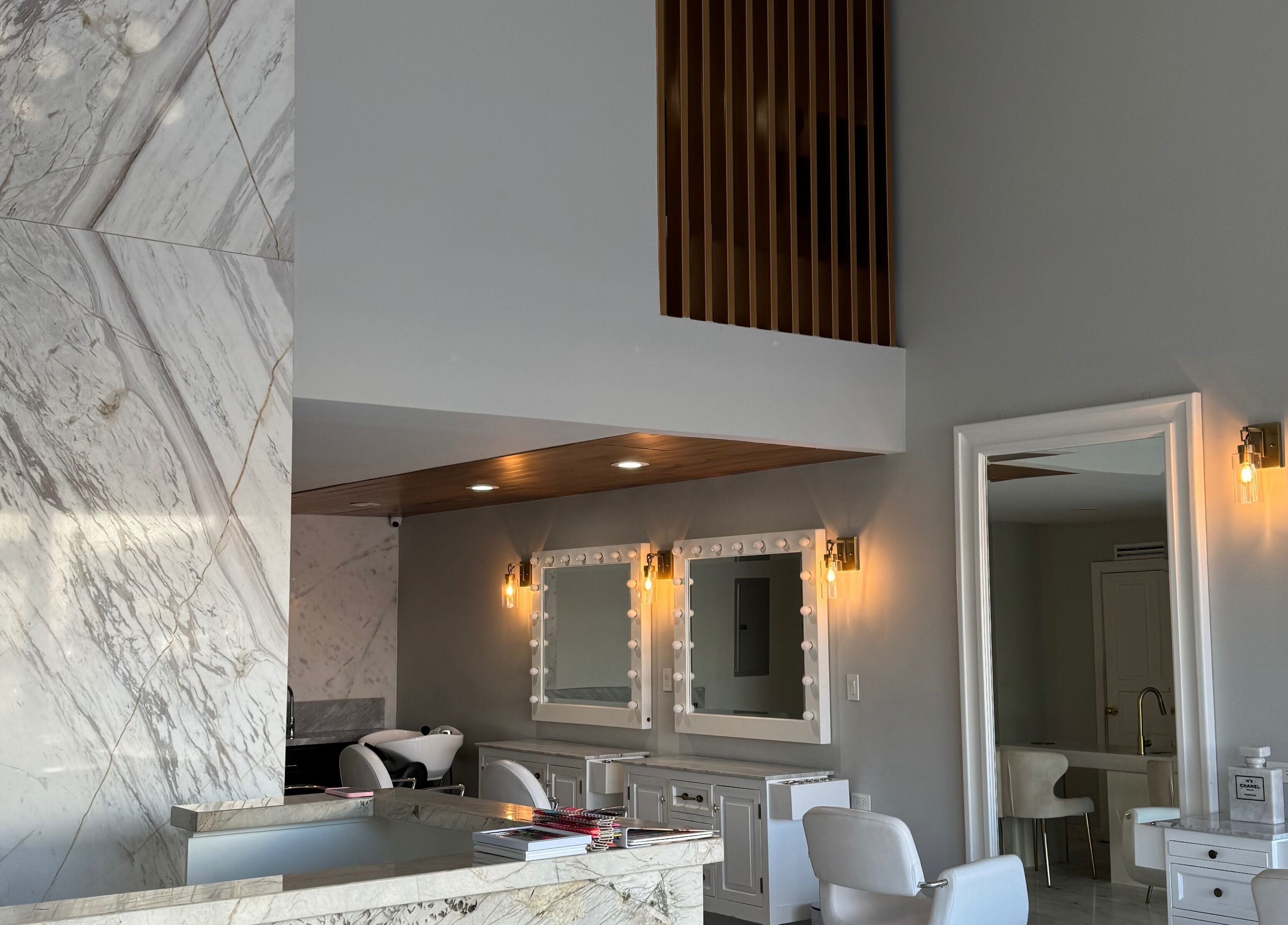 Interior elegante de VICA STUDIO en Chihuahua, Chihuahua, MX, con mostrador de mármol y espejos iluminados.