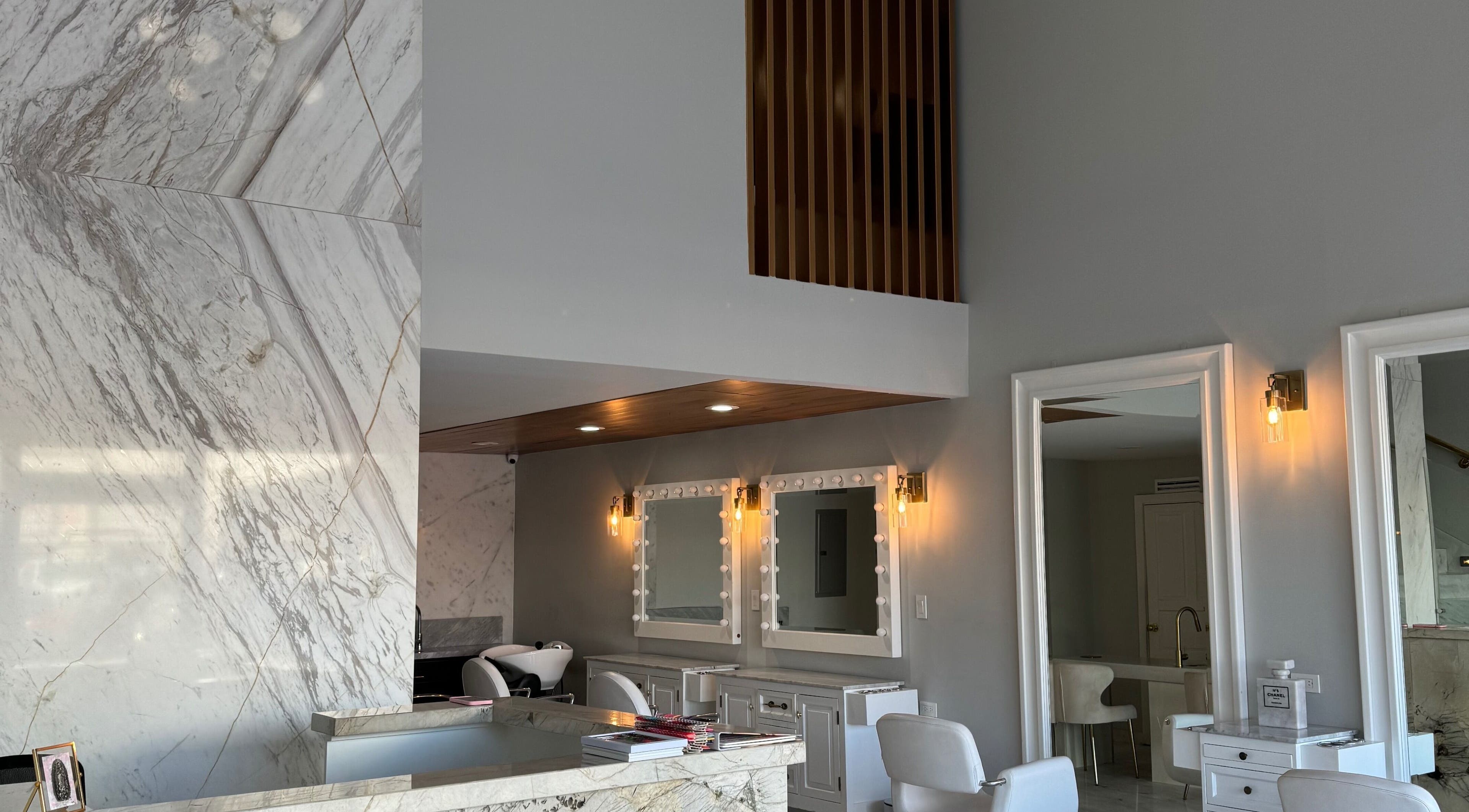 Interior elegante de VICA STUDIO en Chihuahua, Chihuahua, MX, con mostrador de mármol y espejos iluminados.