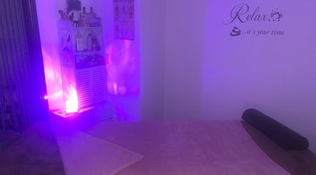 Relaxing massage room at Sparkle Well-being in Saltcoats, Scotland, GB with calming purple lighting.