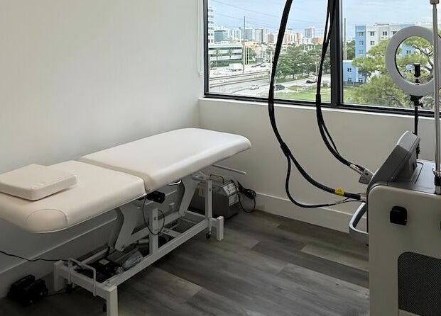 Bright treatment room at THE LAB in Miami, Florida, US, featuring a modern massage bed and professional equipment.
