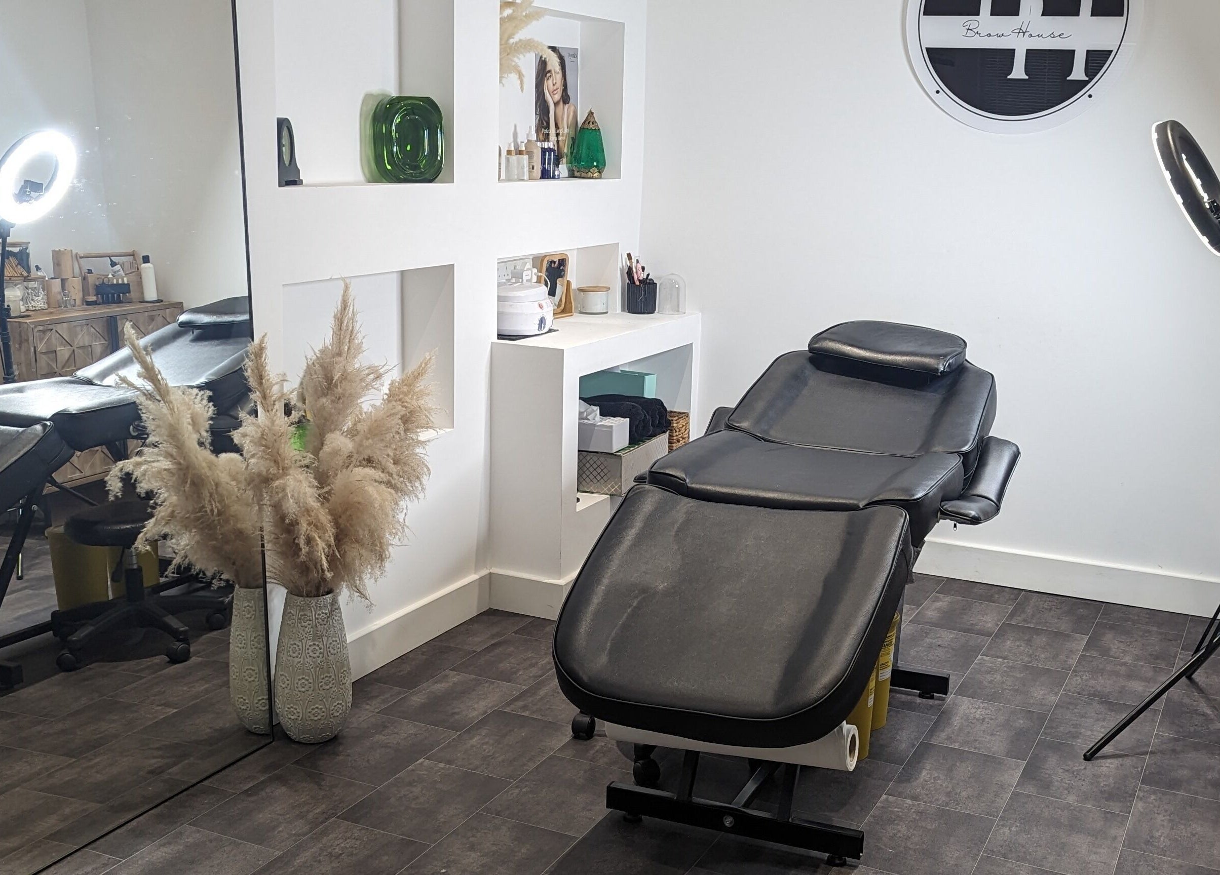 Relaxing treatment room at BrowHouse, Hollingwood, England with modern decor and beauty equipment.