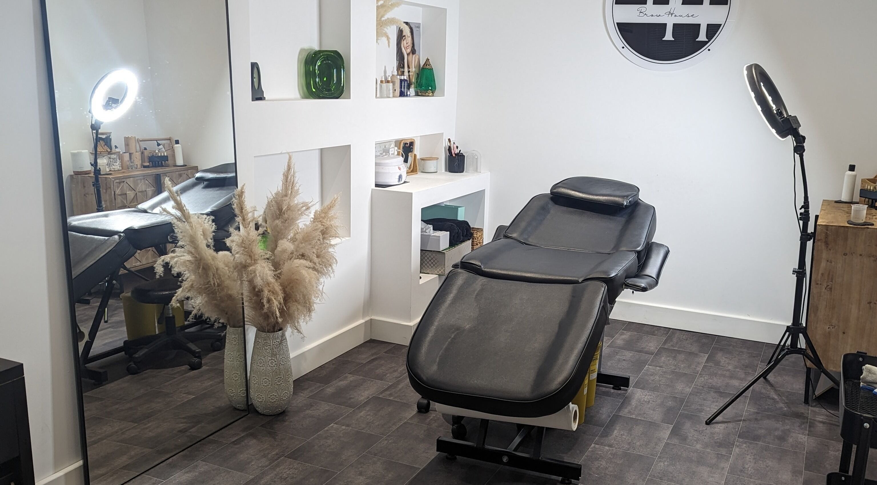 Relaxing treatment room at BrowHouse, Hollingwood, England with modern decor and beauty equipment.