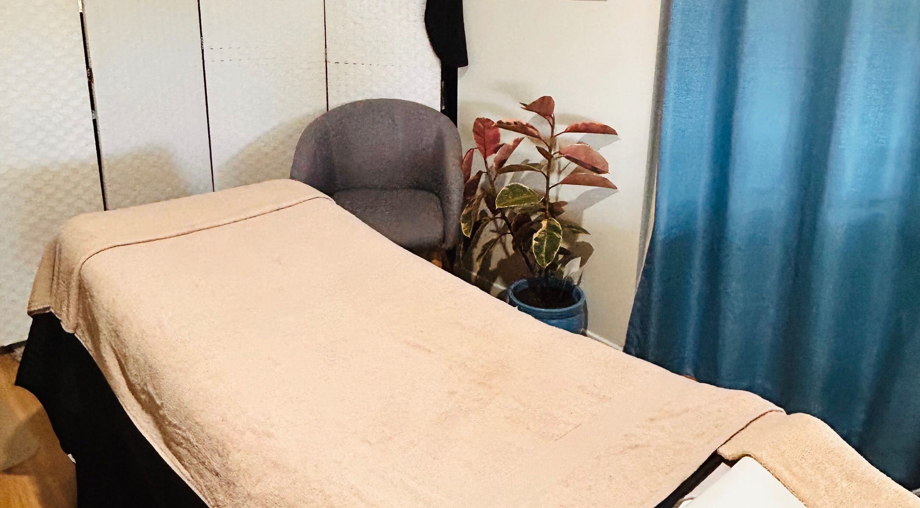 Relaxing massage room at Wild Soul Connection in Hillcrest, Queensland, AU, featuring cozy decor and plant accents.