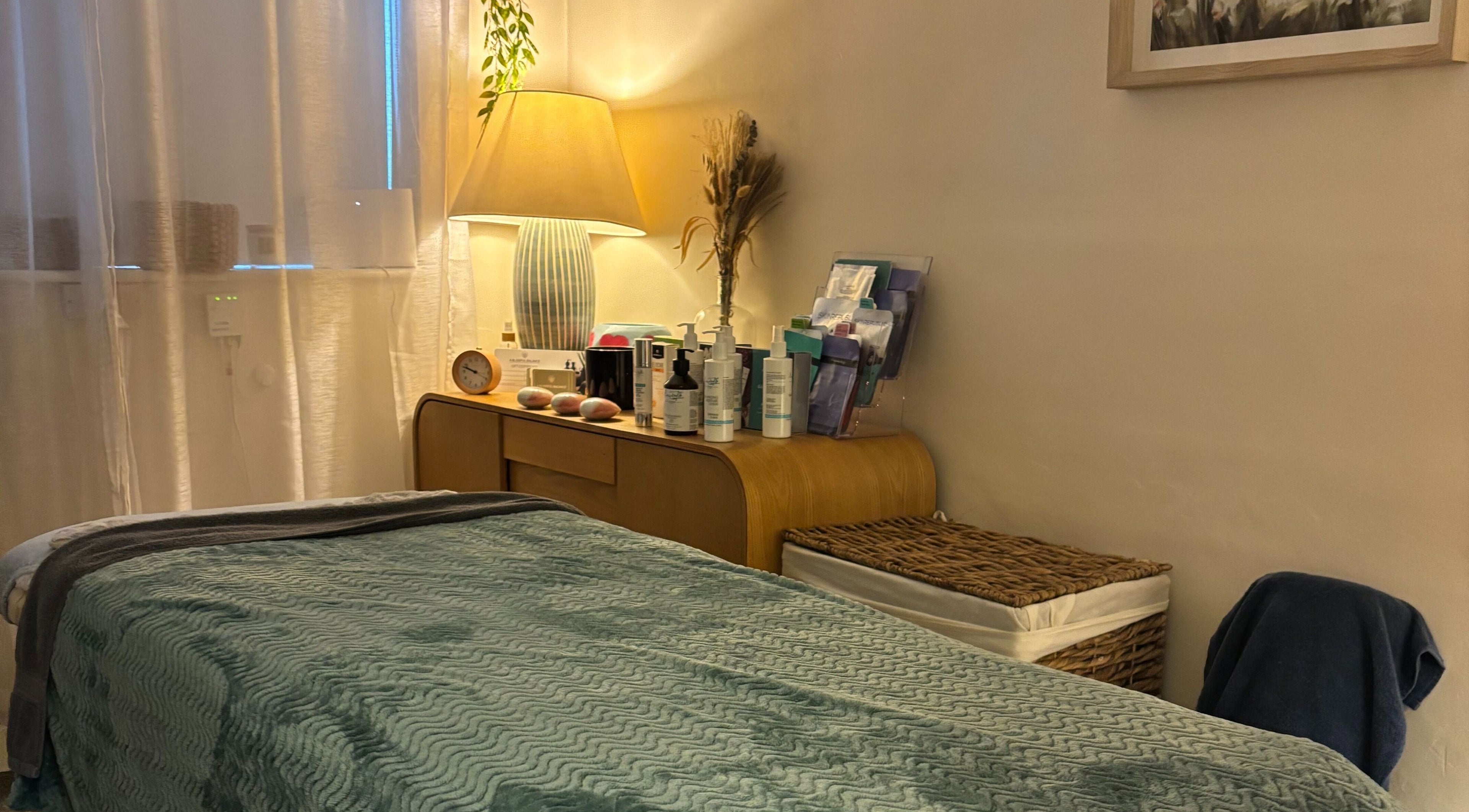 Serene treatment room at A Blissful Balance, Wellesbourne, England, GB with a cozy bed and soft lighting.