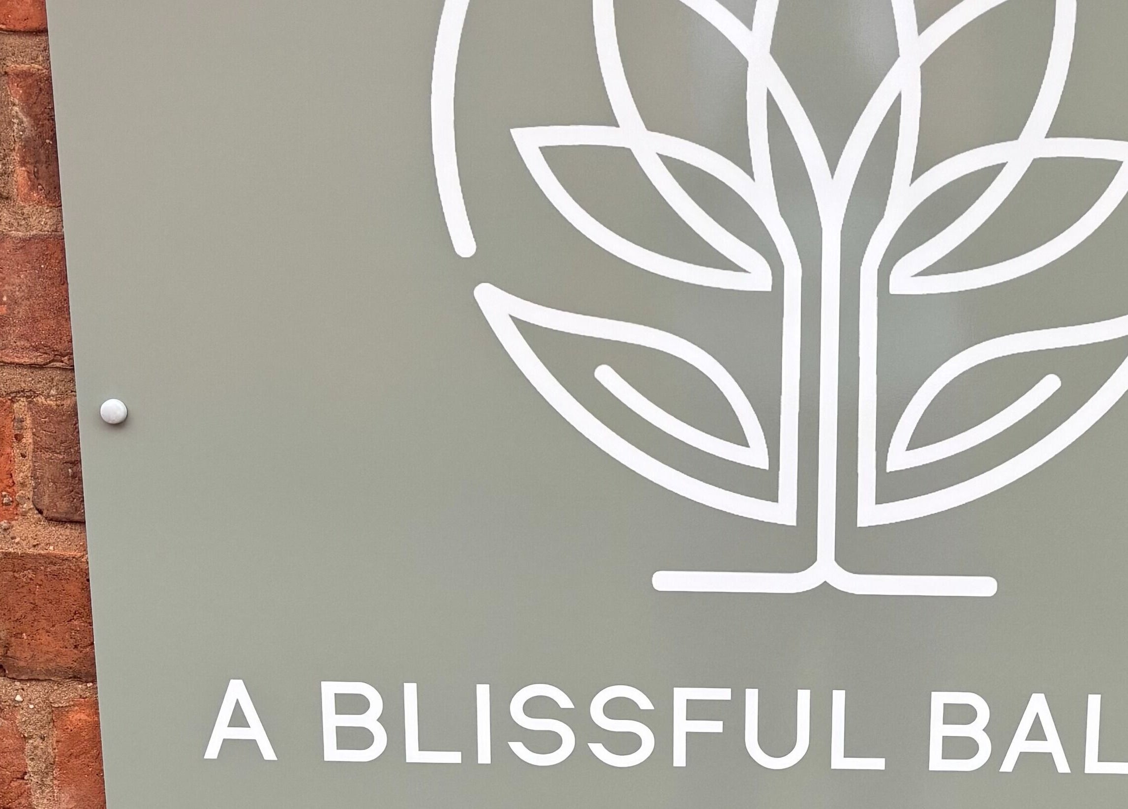 A Blissful Balance logo on a sign in Wellesbourne, England, GB, featuring a leafy design.