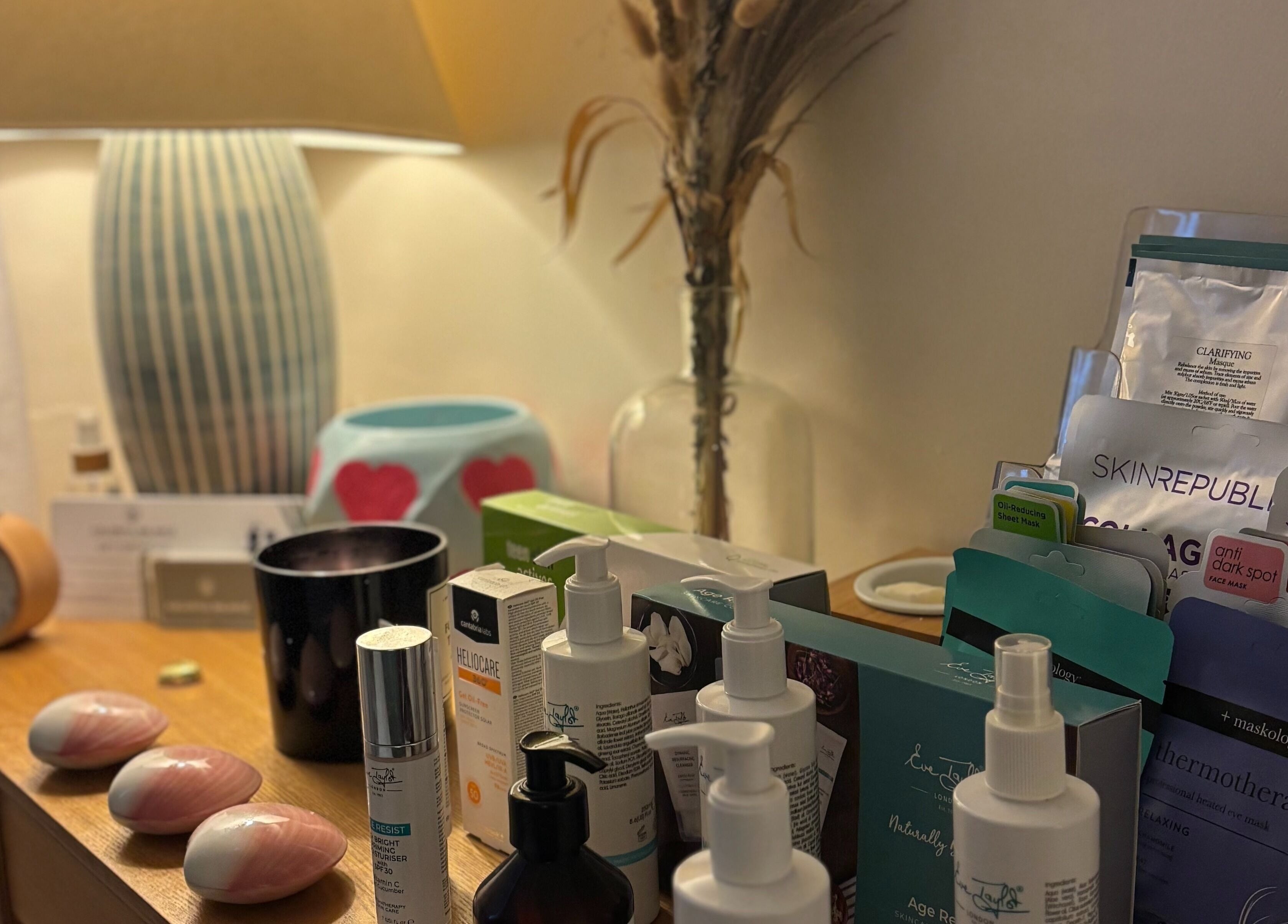 Skincare products displayed at A Blissful Balance, Wellesbourne, England, GB, illuminated by a warm lamp.