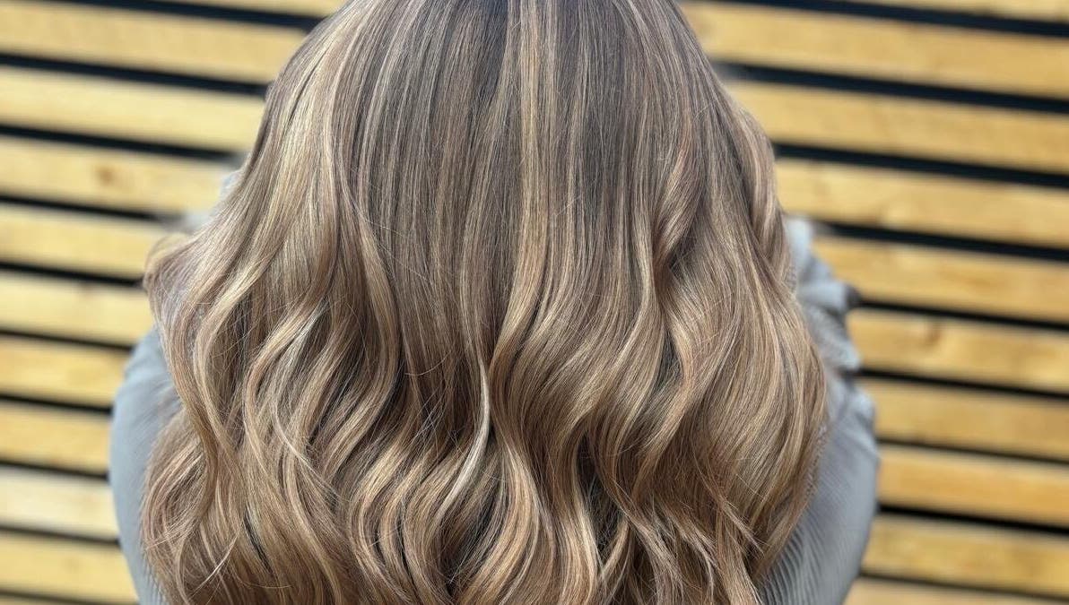 Elegant wavy hairstyle at Hair by Sian Charlton, Cardiff, Wales, GB, showcasing glossy, layered blonde locks.