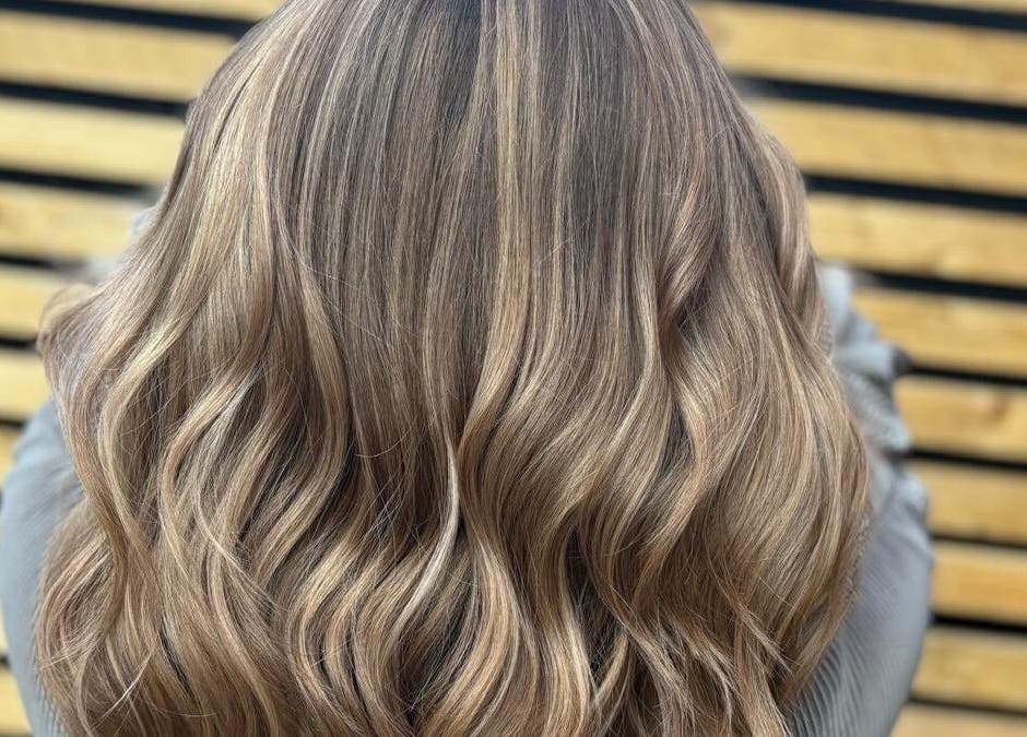 Elegant wavy hairstyle at Hair by Sian Charlton, Cardiff, Wales, GB, showcasing glossy, layered blonde locks.