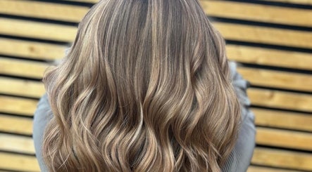 Elegant wavy hairstyle at Hair by Sian Charlton, Cardiff, Wales, GB, showcasing glossy, layered blonde locks.
